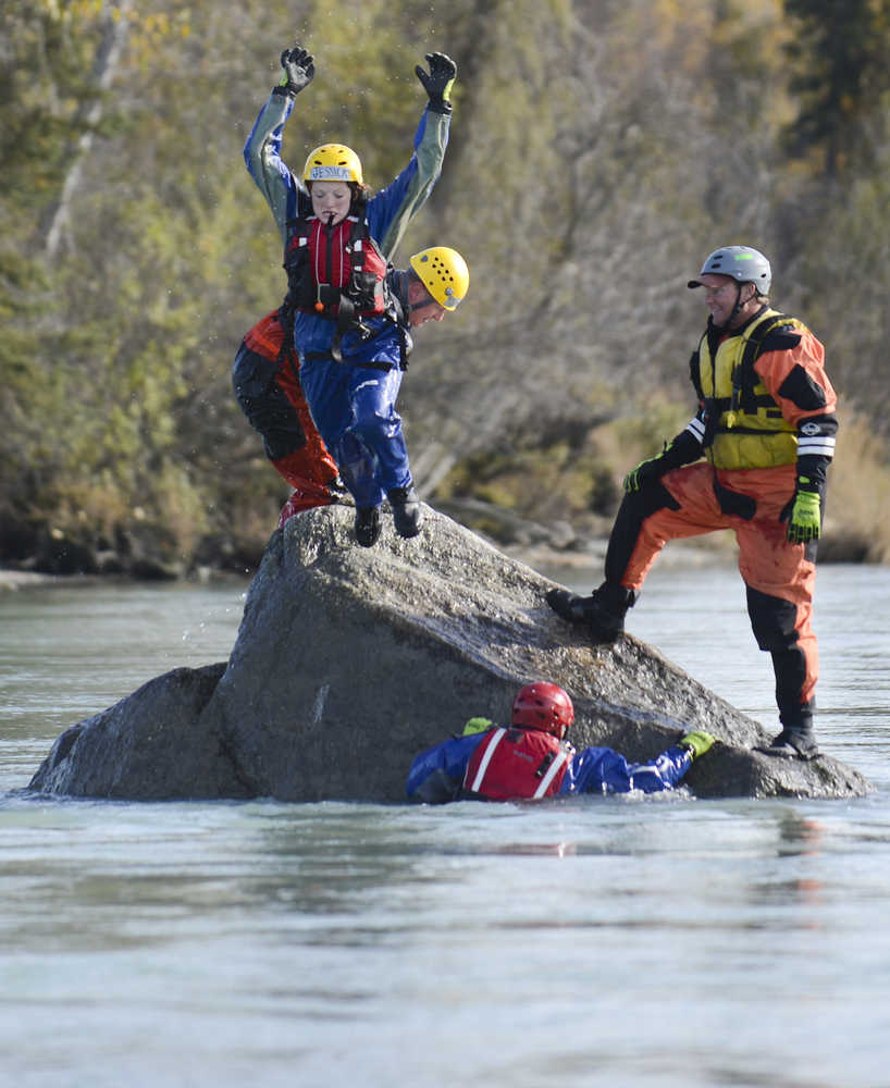 Photo by Rashah McChesney/Peninsula Clarion  Jessica Roper jumps off of Eagle Rock Friday September 27, 2014 as emergency personnel swam in the Kenai River for swift water boat training during the 2014 Alaska Fire Conference on the Kenai Peninsula.