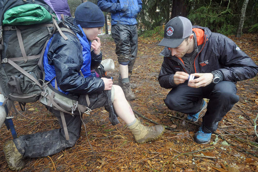 ADVANCE FOR WEEKEND EDITIONS, JAN. 10-11 - In this photo taken on Dec. 20, 2014, Oregon State student Ty Atwater, right, puts makeup on Molly Steiber's leg to simulate a bruise from a broken leg for the final exam in the wilderness first responders class at Oregon State University in Corvallis, Ore. The students took turns role-playing as a hiker with an injury while the other student examines them and treats their injury. (AP Photo/The Corvallis Gazette-Times, Andy Cripe)