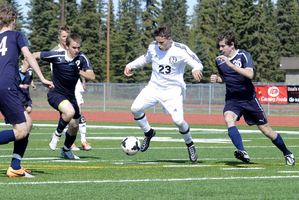keeps the ball away from (left to right) Soldotna's 36, 2, and 24 during a game on Saturday at Kenai Central High School.