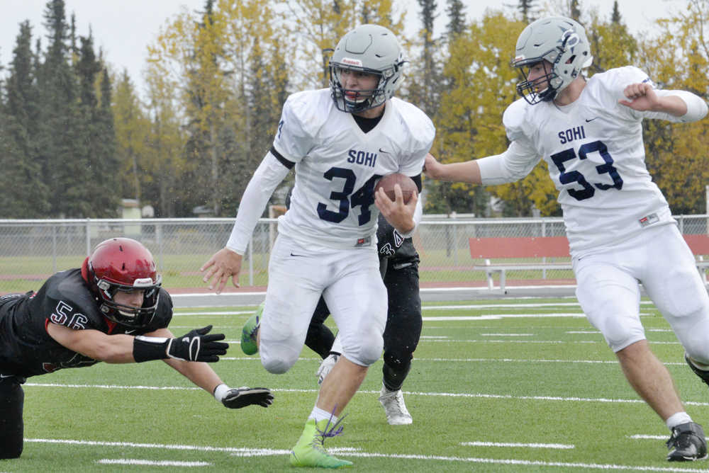 Ben Boettger/Peninsula Clarion Soldotna High School football player Kristian Palaniuk (center) escapes the grasping hands of Kenai's Tobias Randall, with team-mate Sage Hill at his side during a game on Saturday, October 3 at Soldotna High School.