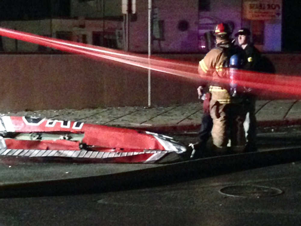 Firefighters stand near a piece of wreckage after a small plane slammed into a commercial building in downtown Anchorage, Alaska, early Tuesday, Dec. 29, 2015. Authorities say at least one person aboard died. Assistant Fire Chief Alex Boyd said there were no injuries on the ground.(AP Photo/Rachel D'Oro)