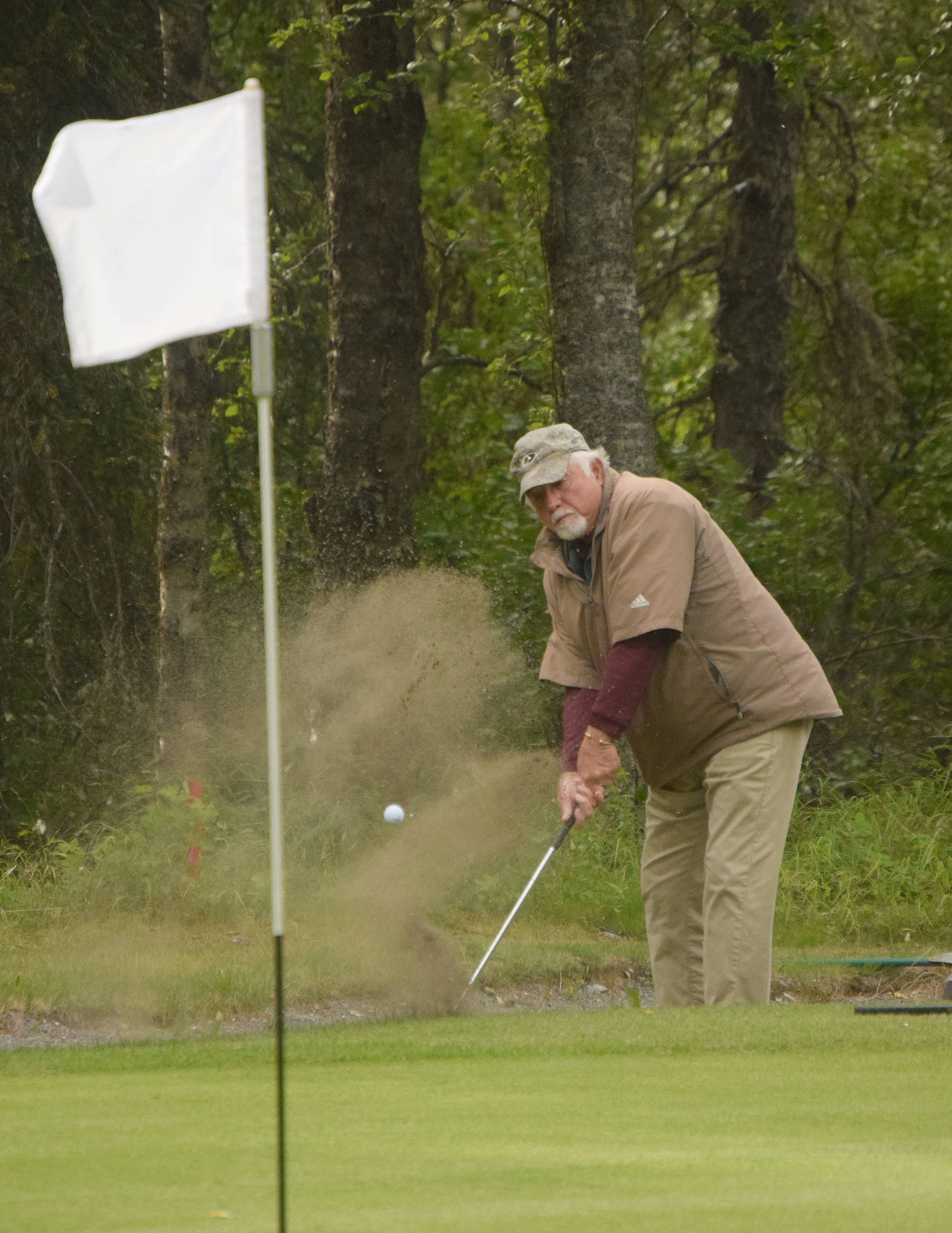 Jerry Norris lifts his ball out of a sand trap on hole No. 3 Sunday in the Kenai Open at the Kenai Golf Course. (Photo by Joey Klecka/Peninsula Clarion)