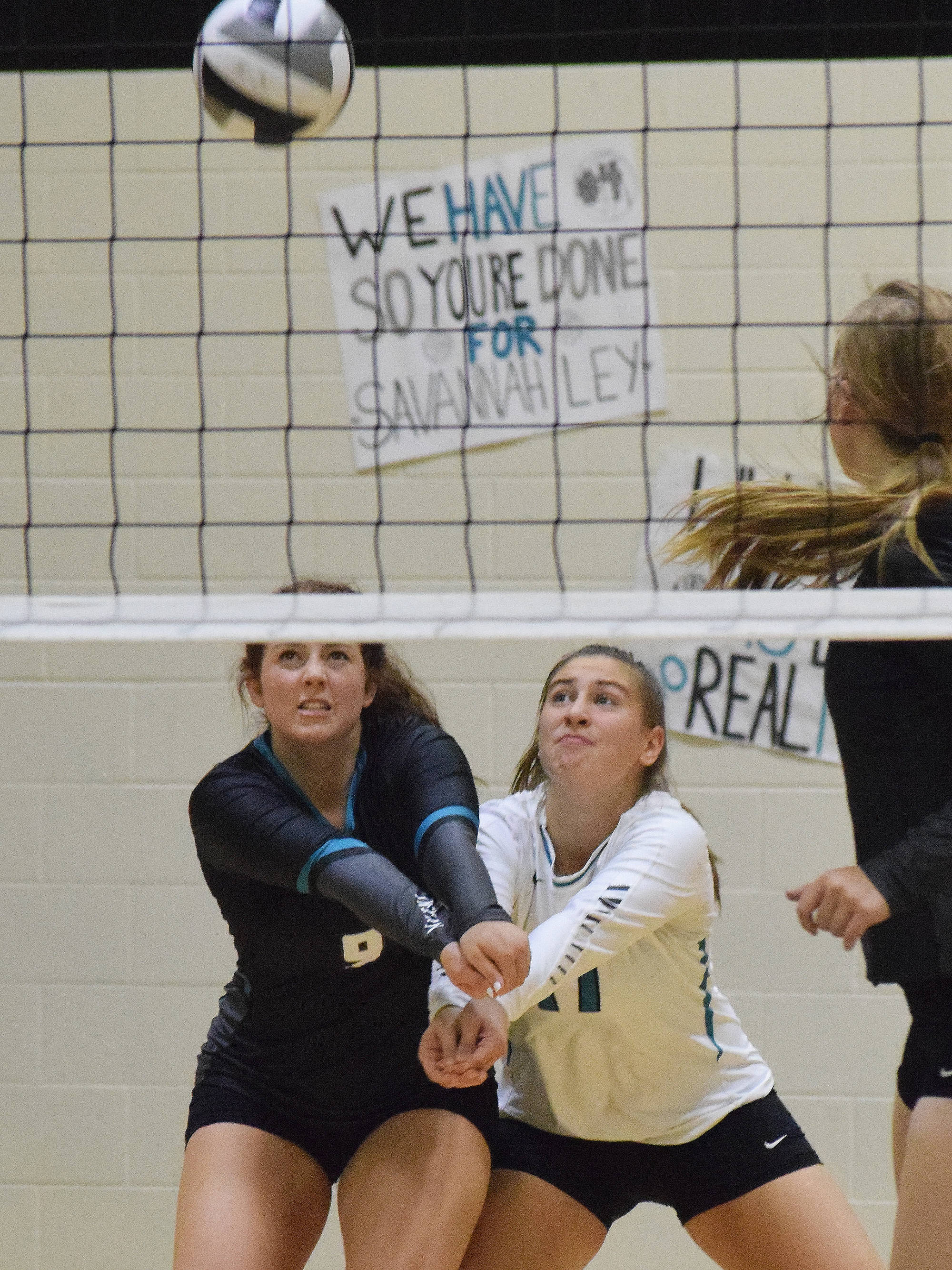 Nikiski teammates Angela Druesedow (left) and Kelsey Clark team up for a dig Saturday against Kenai Central at the Shayna Pritchard Memorial tournament at Nikiski High School. (Photo by Joey Klecka/Peninsula Clarion)