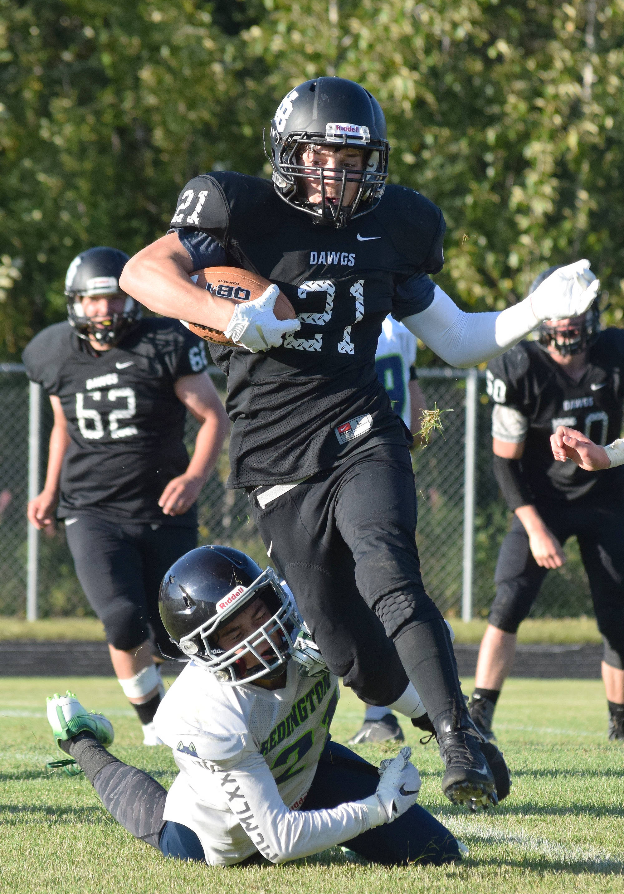 Nikiski senior Brock Sarks (21) cuts through a field of Redington defenders Friday against the Redington Huskies at Nikiski High School. (Photo by Joey Klecka/Peninsula Clarion)