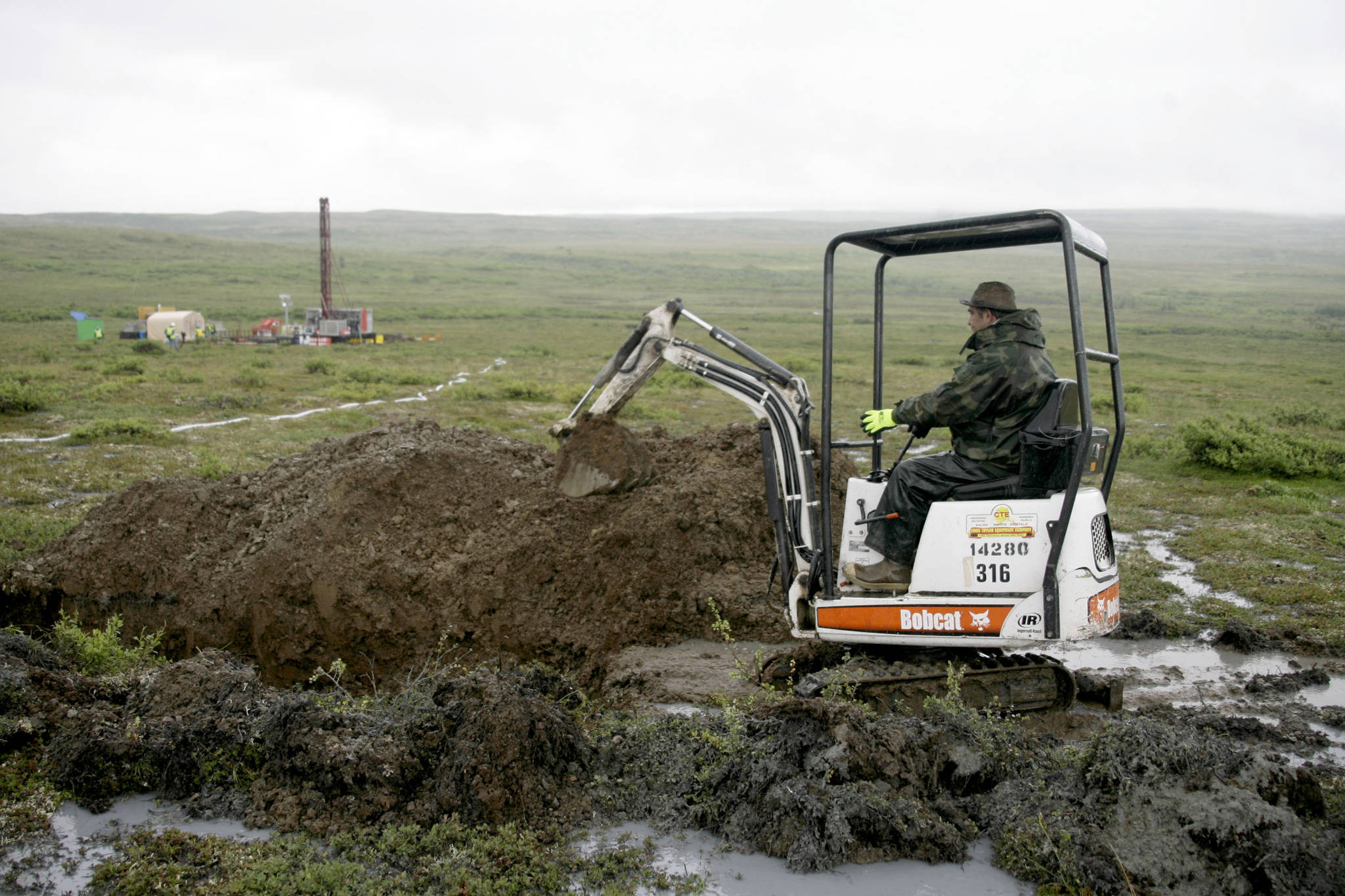 FILE - In this July 13, 2007 file photo, a worker with the Pebble Mine project digs in the Bristol Bay region of Alaska near the village of Iliamma, Alaska. The Trump administration settled a lawsuit Friday, May 12, 2017, over the proposed development of a massive copper and gold deposit near the headwaters of a world-premier salmon fishery in southwest Alaska. (AP Photo/Al Grillo,File)