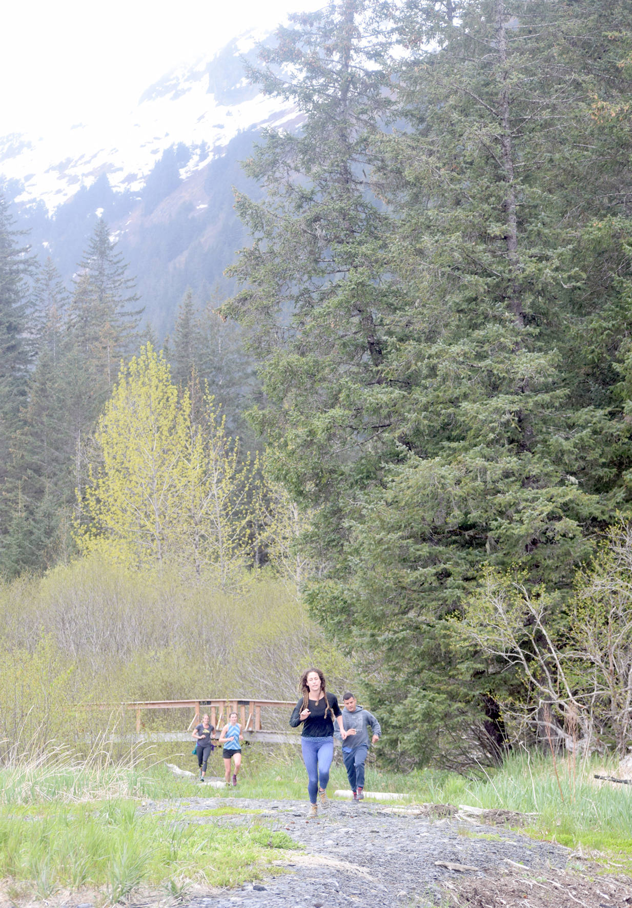 Kelly Ann Cope, Nathan, Sabrina Farmer and Ella Wright run out onto the beach during the Dixon/Holden Memorial Tonsina Beach Trail Run on Wednesday, May 30, 2018, in Seward. (Photo by Jeff Helminiak/Peninsula Clarion)