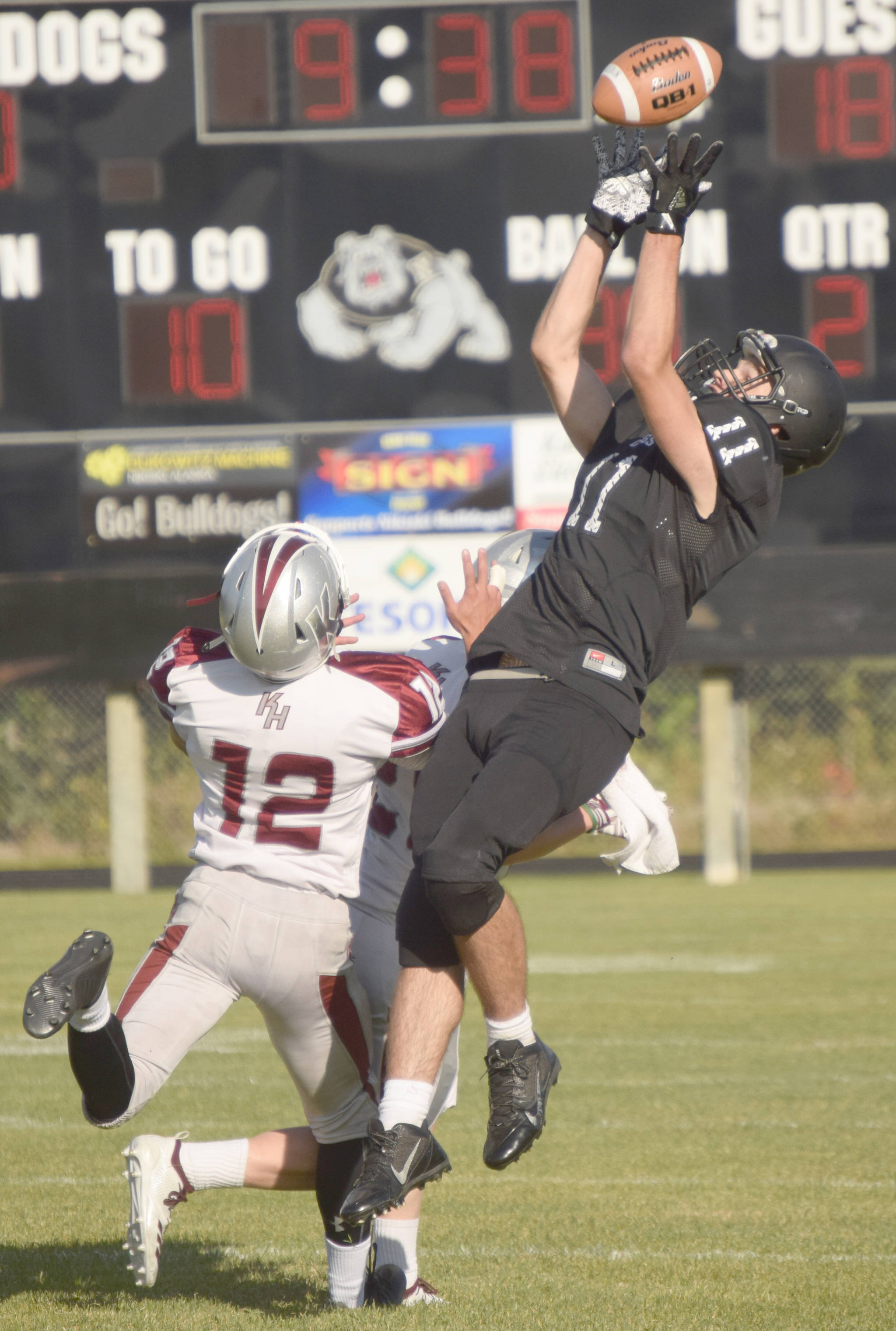 Nikiski’s Michael Eiter grabs the ball over Ketchikan’s Mark Jasper and Tyler McLaren on Friday, Aug. 31, 2018, at Nikiski High School. Eiter had eight catches for 176 yards. (Photo by Jeff Helminiak/Peninsula Clarion)