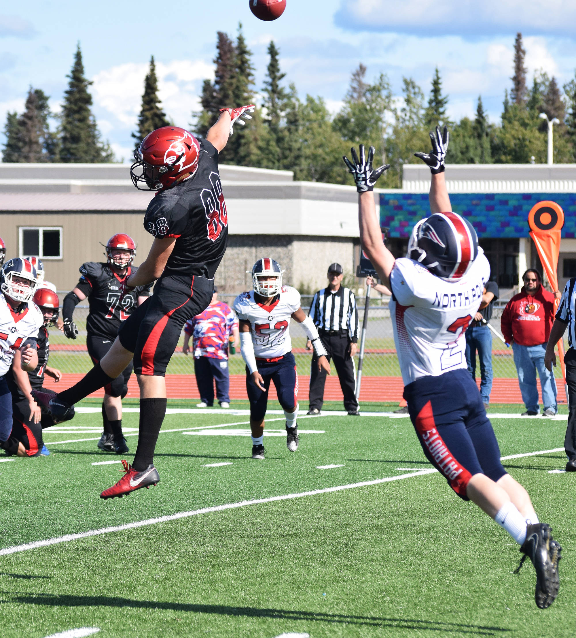 Kenai’s Braedon Pitsch (88) gets his fingers on a ball intended for North Pole’s Riley Walters (2) Saturday at Ed Hollier Field in Kenai. (Photo by Joey Klecka/Peninsula Clarion)