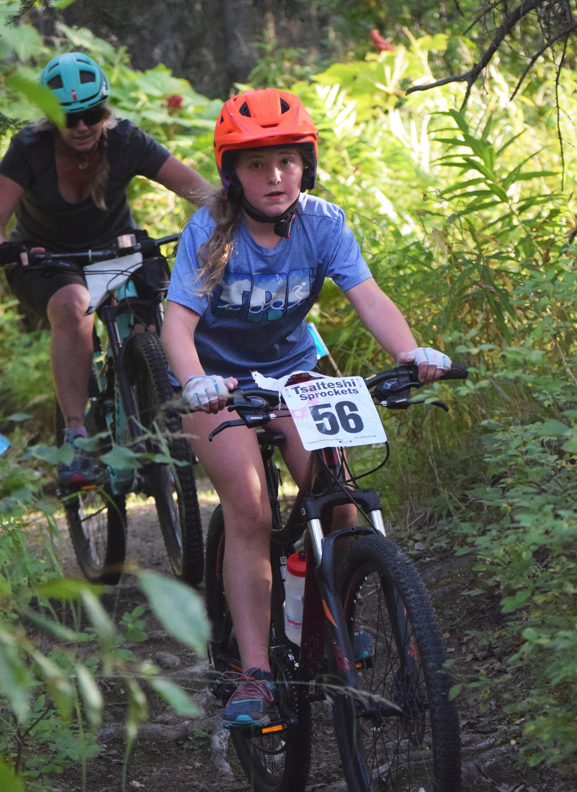 Audrey McDonald (56) rides through a narrow section of trail in the Soldotna Cycle Series season finale held Aug. 30, 2018, at the Tsalteshi Trails. (Photo by Joey Klecka/Peninsula Clarion)