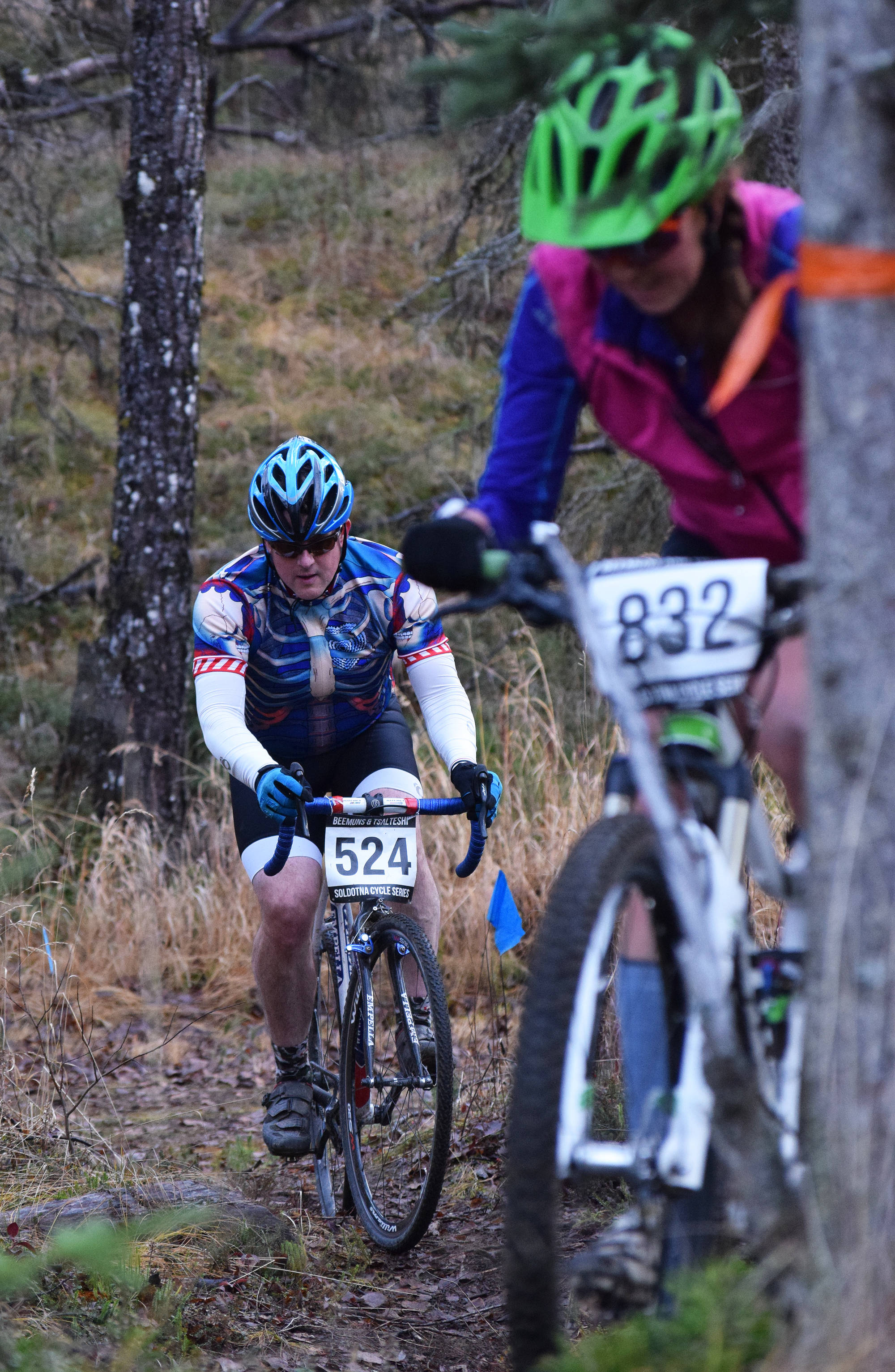 Kenai rider Will Morrow (524) chases after Tasha DiMarzio in the Polar Vortex Cyclocross race Saturday at the Tsalteshi Trails in Soldotna. (Photo by Joey Klecka/Peninsula Clarion)