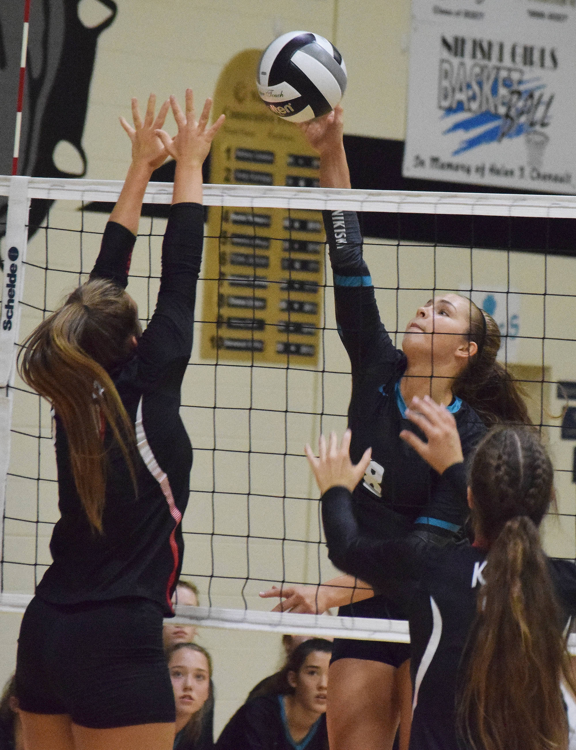 Nikiski junior Kaitlyn Johnson (right) meets Kenai’s Jaiden Streiff at the net Aug. 25, 2018, at the Shayna Pritchard Memorial tournament at Nikiski High School. (Photo by Joey Klecka/Peninsula Clarion)