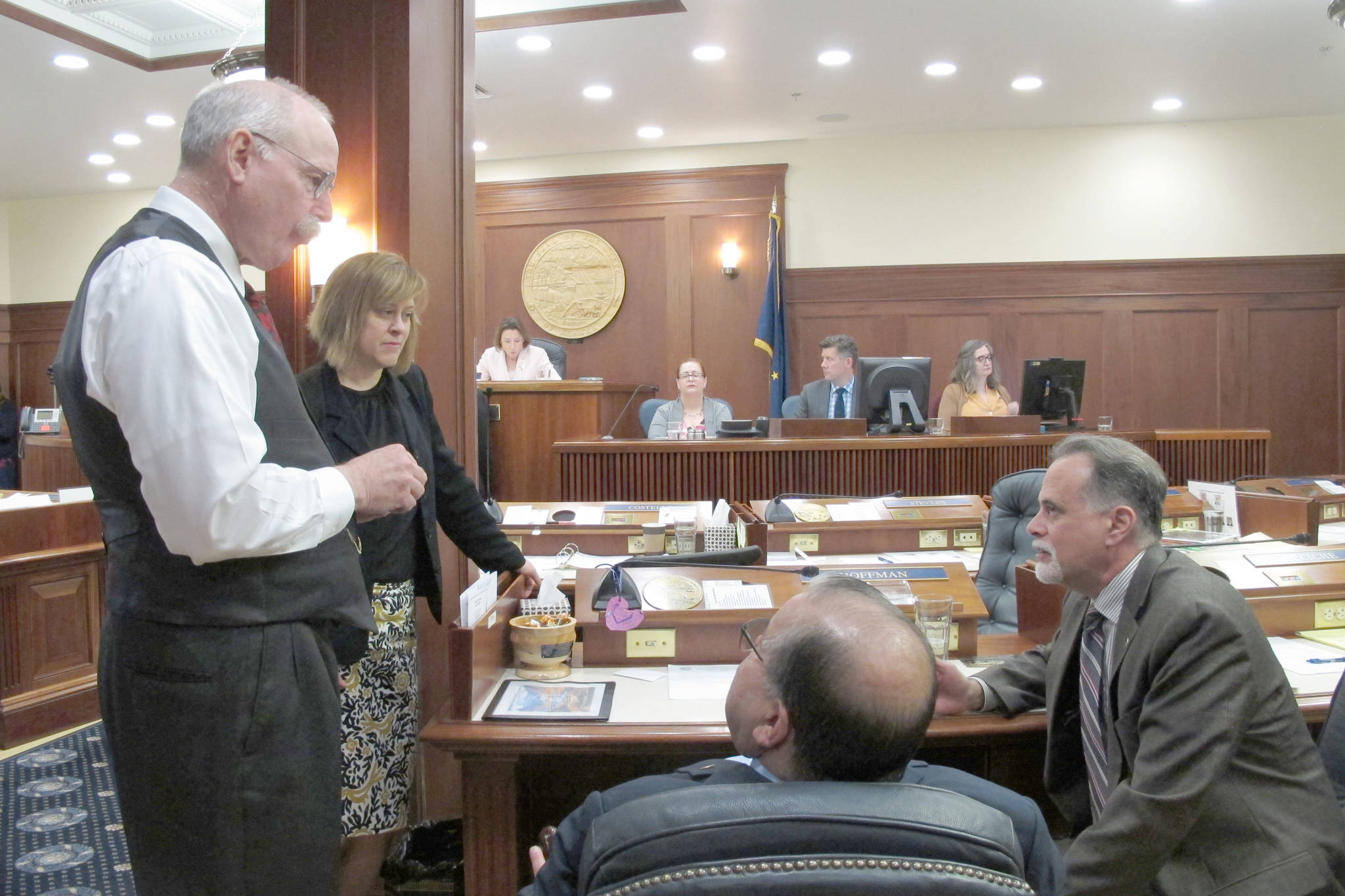 From left, Alaska Sens. Bert Stedman, Mia Costello, Lyman Hoffman and Peter Micciche speak during a break on the Senate floor on Tuesday, June 4, 2019, in Juneau, Alaska. The Senate on Tuesday failed to pass a bill that would have paid a full dividend from Alaska’s oil-wealth fund, the Alaska Permanent Fund, this year. (AP Photo/Becky Bohrer)