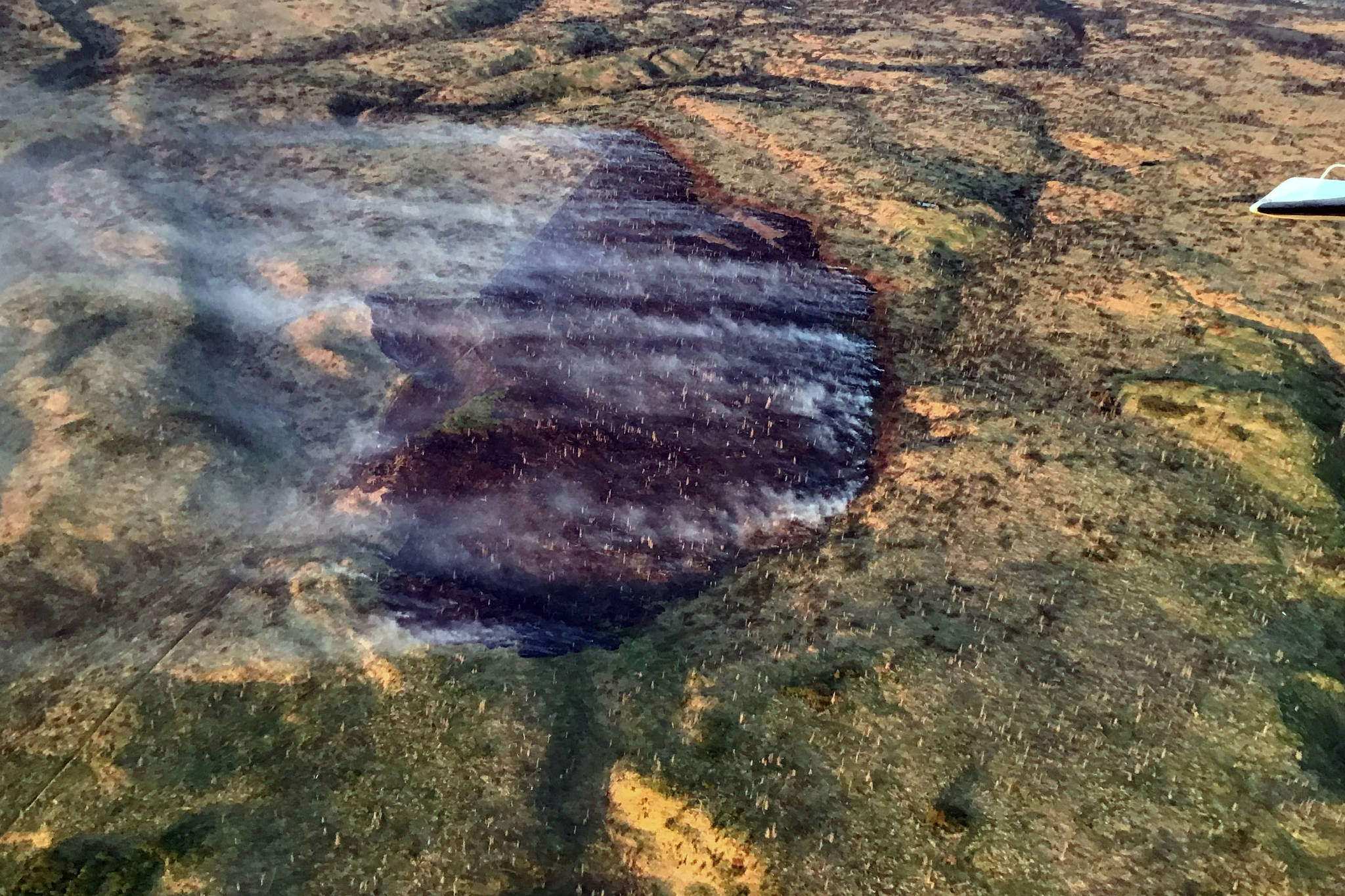 A photo of the Tustumena Lake Fire taken at 11 p.m. on Wednesday illustrates the effect retardant and water drops had on the fire. (Photo by Jason Jordet/Alaska Division of Forestry)