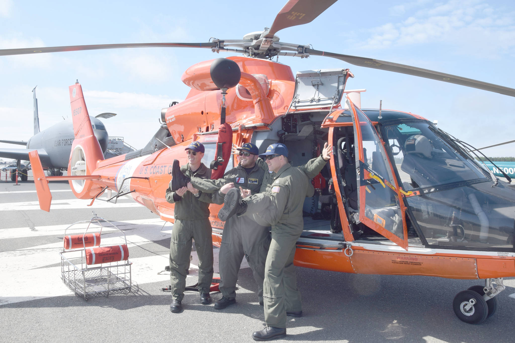 From right, Wes Jones, Jake Pritchett, Austin Robinson and Jay Kircher pose for a photo in front of a Eurocopter MH-65 Dolphin at the 19th annual Kenai Peninsula Air Fair in Kenai, on Saturday. The four are part of a U.S. Coast Guard Search and Rescue Team based out of Kodiak. (Photo by Brian Mazurek/Peninsula Clarion)