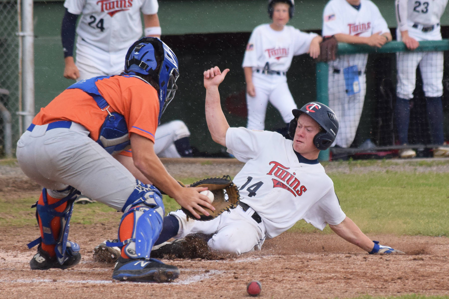 Twins pitcher Mose Hayes (14) slides safely into home ahead of the tag of Palmer catcher Brady Shults Tuesday, July 16, 2019, at Coral Seymour Memorial Park in Kenai, Alaska. (Photo by Joey Klecka/Peninsula Clarion)