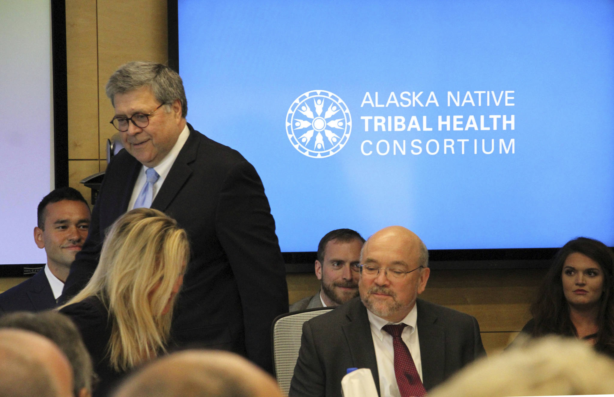 In this May 29, 2019 file photo U.S. Attorney General William Barr, standing, greets participants at a roundtable discussion at the Alaska Native Tribal Health Consortium in Anchorage, Alaska. Alaska Native villages are receiving almost $5 million from the U.S. Justice Department to combat numerous public safety problems, including no law enforcement presence in some communities. The announcement Tuesday, July 30, 2019, comes nearly two months after Barr met with tribal representatives during a visit to the state who detailed slow response times from authorities, violence against women and abuse of alcohol and drugs, including opioids. (AP Photo/Mark Thiessen, File)