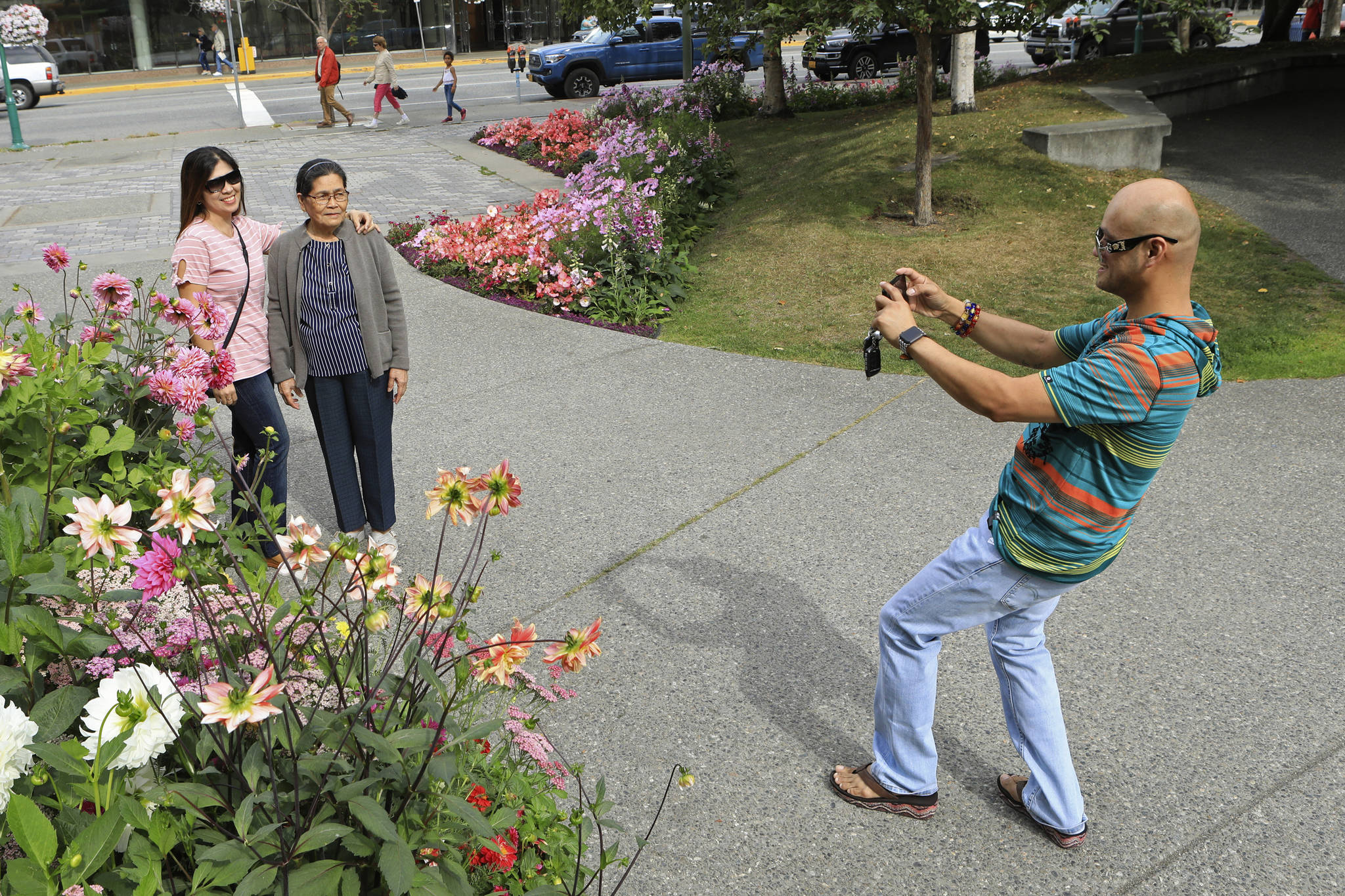 DAN JOLING/ASSOCIATED PRESS                                Junar Lim takes photos of Ziah Lim, left, and Arsenia Lim, all of Cavite, the Philippines, at gardens in Town Square in Anchorage Thursday. Alaska recorded its warmest month ever in July and hot, dry weather has continued in Anchorage and much of the region south of the Alaska Range.