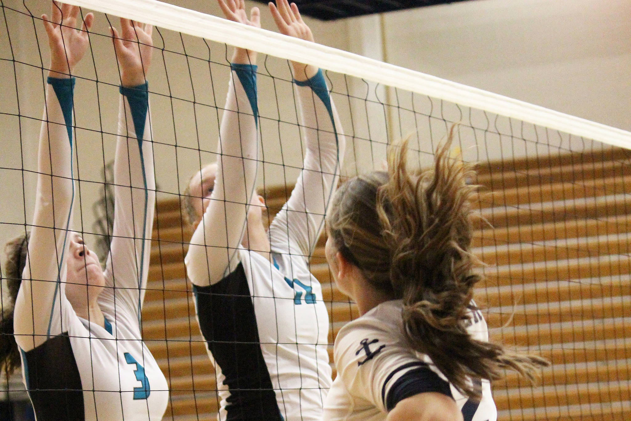 Nikiski’s America Jeffreys (left) and Kaycee Bostic put up a block on Homer’s Laura Inama at the Homer Jamboree against the Homer Mariners on Saturday, Aug. 24, 2019 in the Alice Witt Gymnasium in Homer, Alaska. (Photo by Megan Pacer/Homer News)