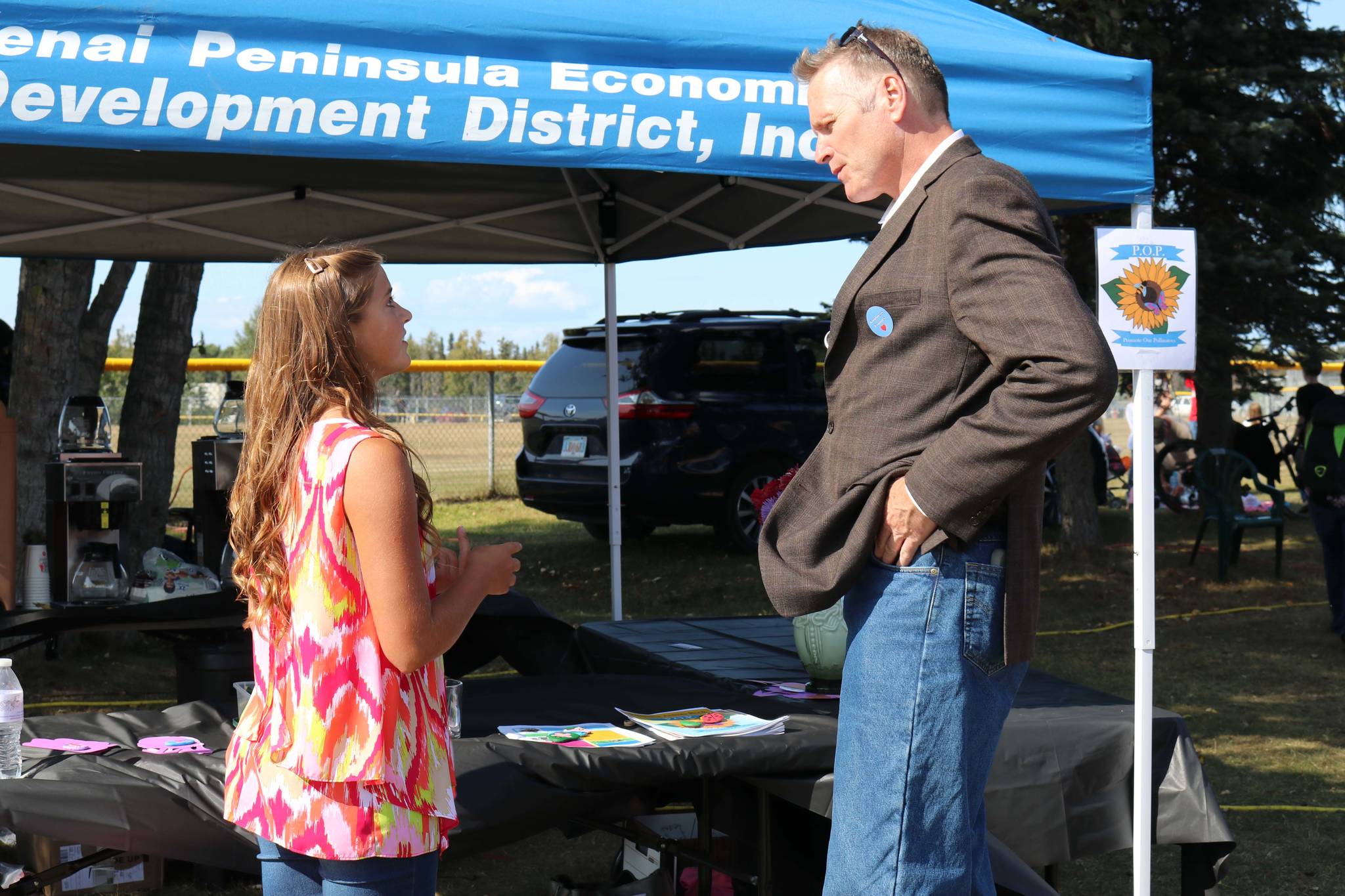 Anna Devolld speaks with Governor Mike Dunleavy about her Promote our Pollinators project at Industry Appreciation Day at the Kenai Park Strip in Kenai, Alaska on Aug. 24, 2019. (Photo courtesy Shona Devolld)