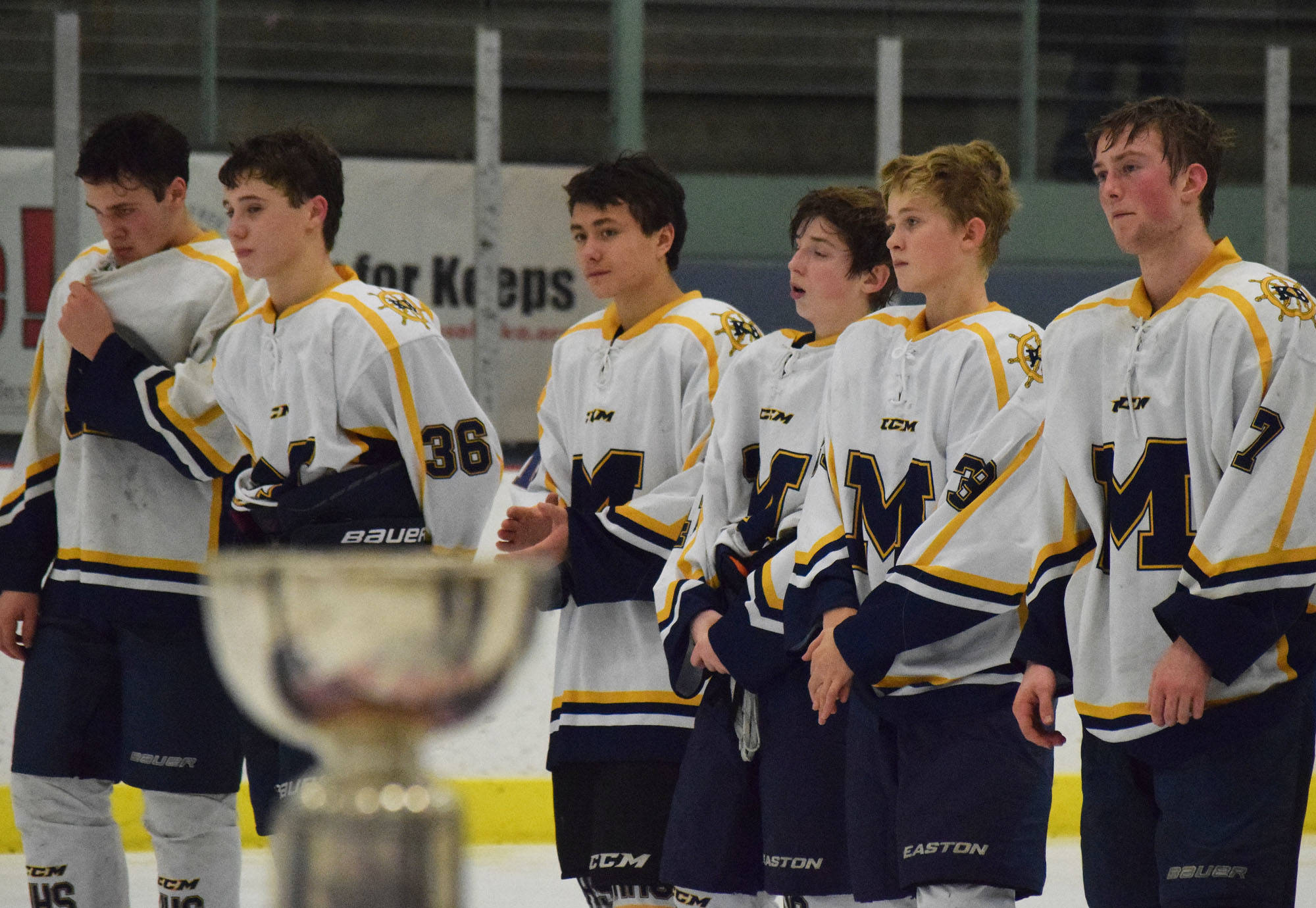 Members of the Homer hockey team watch postgame ceremonies Saturday night after losing 6-5 in overtime to Palmer in the Div. II championshipat the Curtis Menard Sports Complex in Wasilla. (Photo by Joey Klecka/Peninsula Clarion)