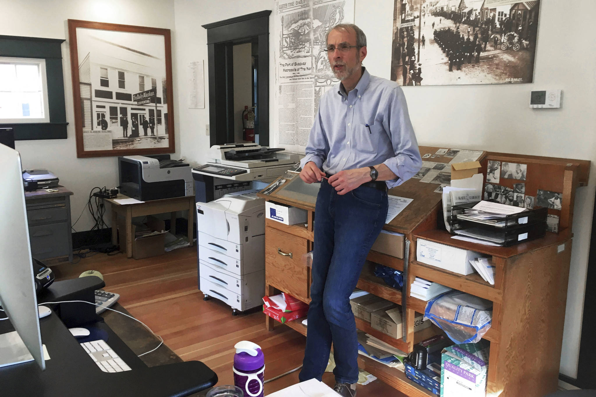 This May 29, 2019 photo shows Larry Persily, the publisher of The Skagway News, in the newspaper office in Skagway, Alaska. If you’ve ever wanted to own a small bi-weekly newspaper in Alaska but didn’t have the money, this could be your chance. The publisher of The Skagway News is willing to give the paper away to the right person, if they are willing to move to the southeast Alaska community and be a part of the community. Persily says he’s willing to help out the new owners by giving away the paper because the advertising will afford them a living wage, but not on top of a mortgage. (Molly McCammon via AP)