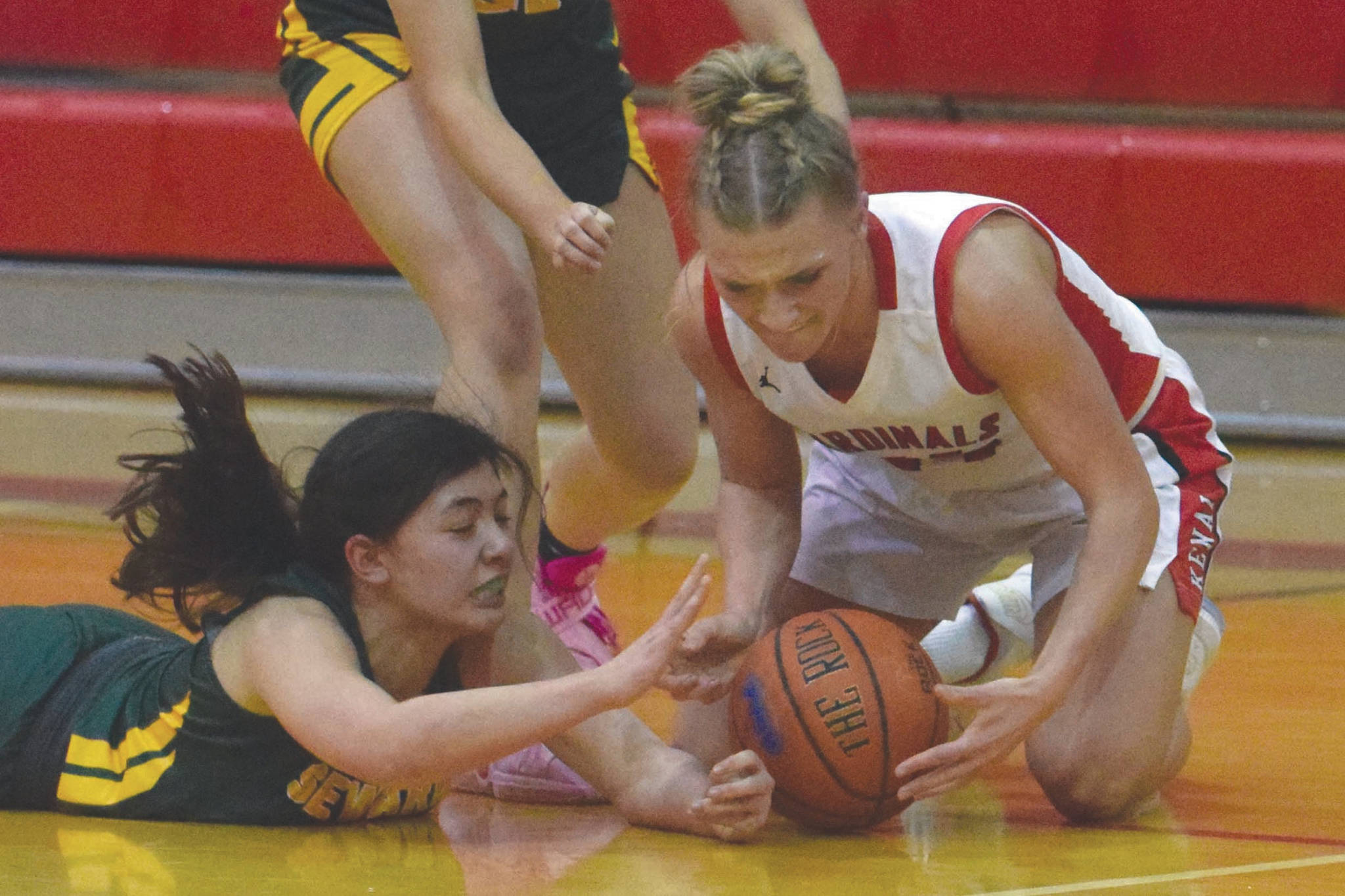 Seward’s Anevay Ambrosiani and Sequoia Sieverts fight with Kenai’s Damaris Severson for the ball Friday, Feb. 28, 2020, at Kenai Central High School in Kenai, Alaska. (Photo by Jeff Helminiak/Peninsula Clarion)