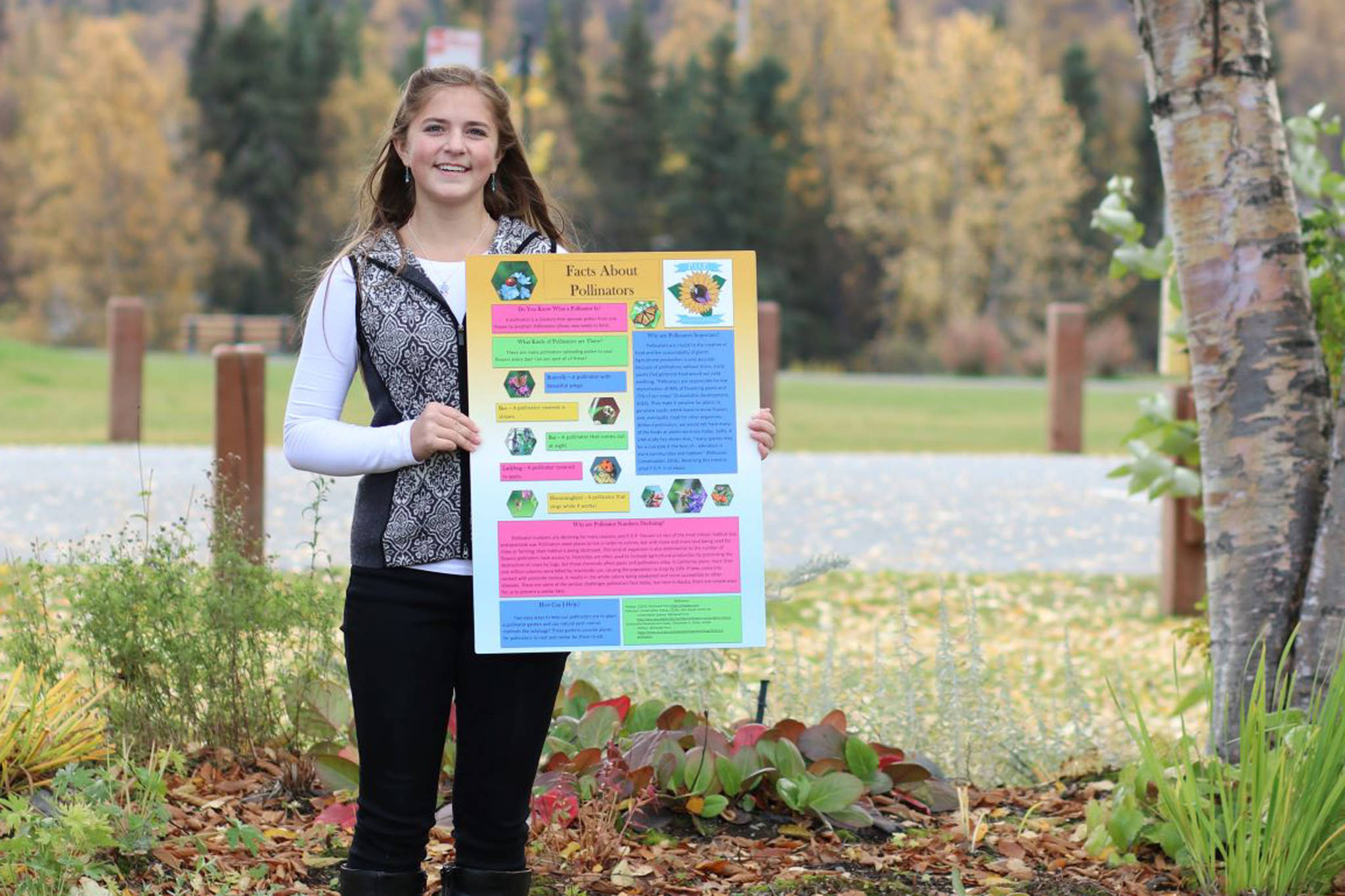 Anna DeVolld poses with an informational poster for her Promote Our Pollinators project in this undated photo. (Photo courtesy Shona DeVolld)