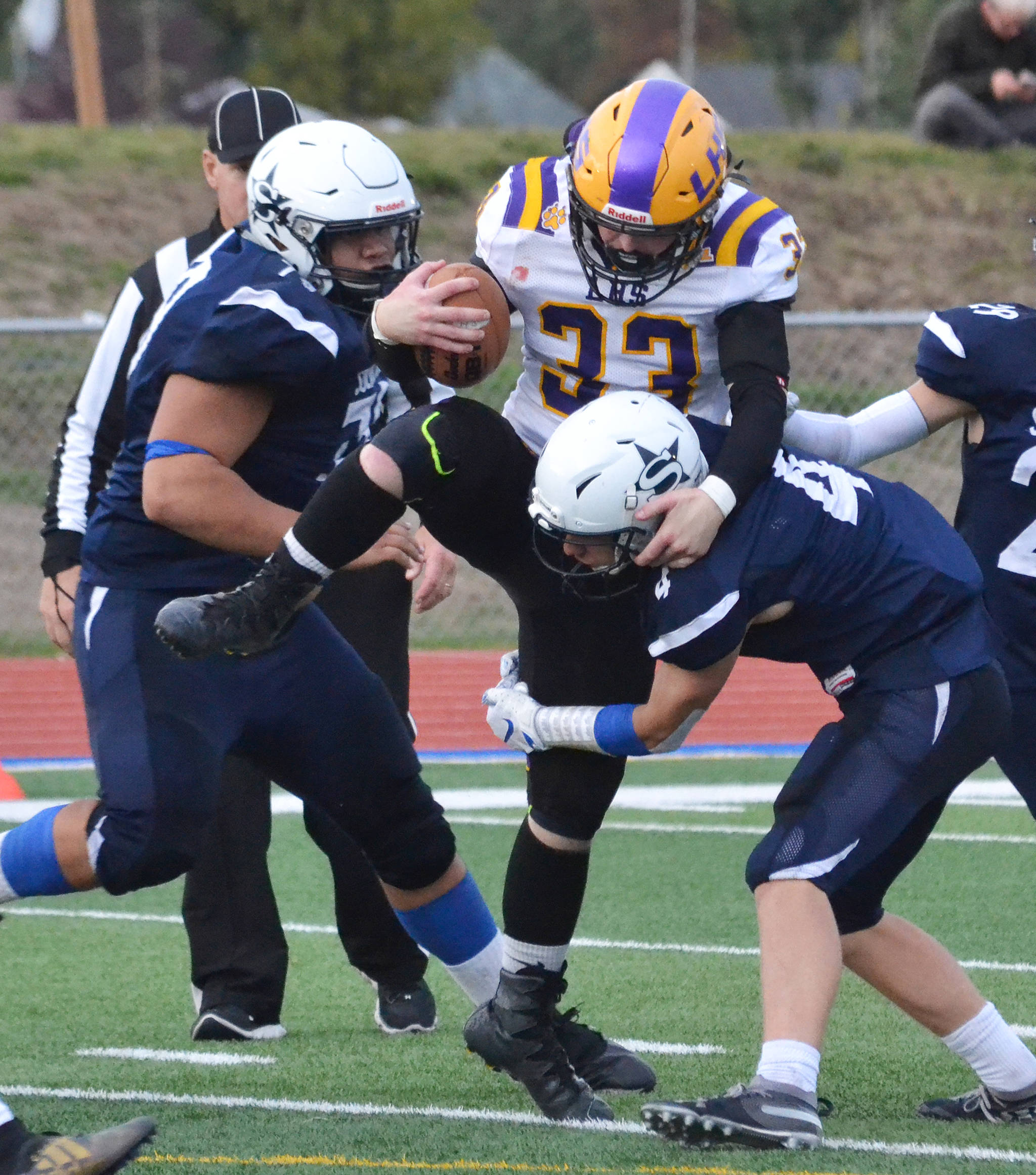 Lathrop running back Josiah Opp gets swarmed by Soldotna’s Melvin Lloyd (left) and Jersey Truesdell Friday, Sept. 13, 2019, at Justin Maile Field in Soldotna, Alaska. (Photo by Joey Klecka/Peninsula Clarion)