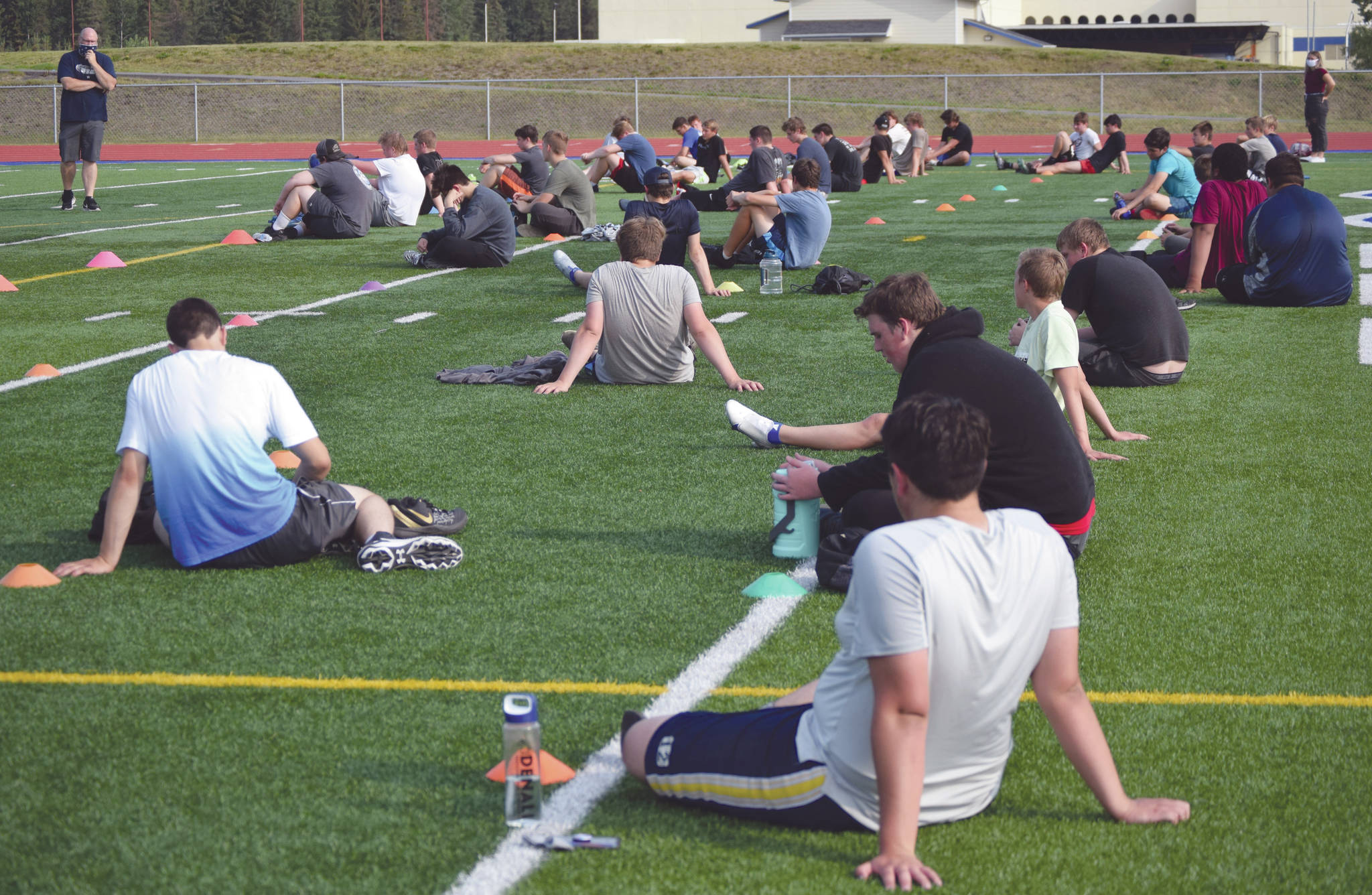 Soldotna football coach Galen Brantley Jr., at top left, addresses a socially distanced team on the first day of practice Wednesday in Soldotna.