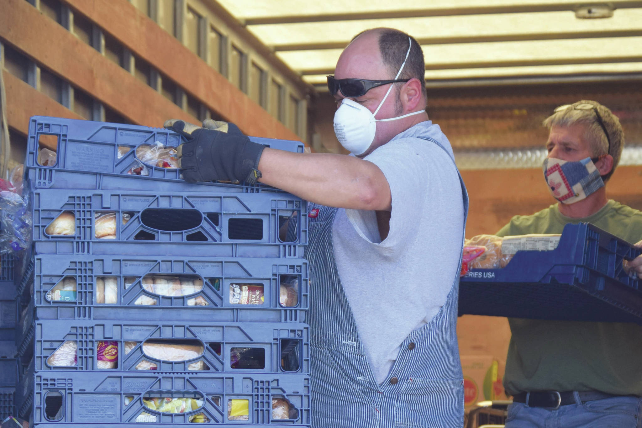 John Webster and Duane Jennings with the Kenai Peninsula Food Bank unload a truck at the food bank just outside of Soldotna, Alaska, on Tuesday, Aug. 4, 2020. (Photo by Jeff Helminiak/Peninsula Clarion)