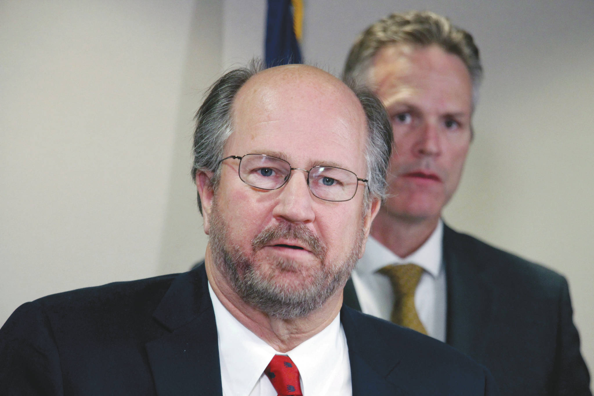 In this Sept. 26, 2019, file photo, Alaska Attorney General Kevin Clarkson, left, addresses reporters as Gov. Mike Dunleavy, right, looks on in Anchorage, Alaska. Clarkson has resigned, shortly after details of text messages that the state’s married and socially conservative top law enforcement officer sent to a female state employee were revealed Tuesday, Aug. 25, 2020. (AP Photo/Mark Thiessen, File)