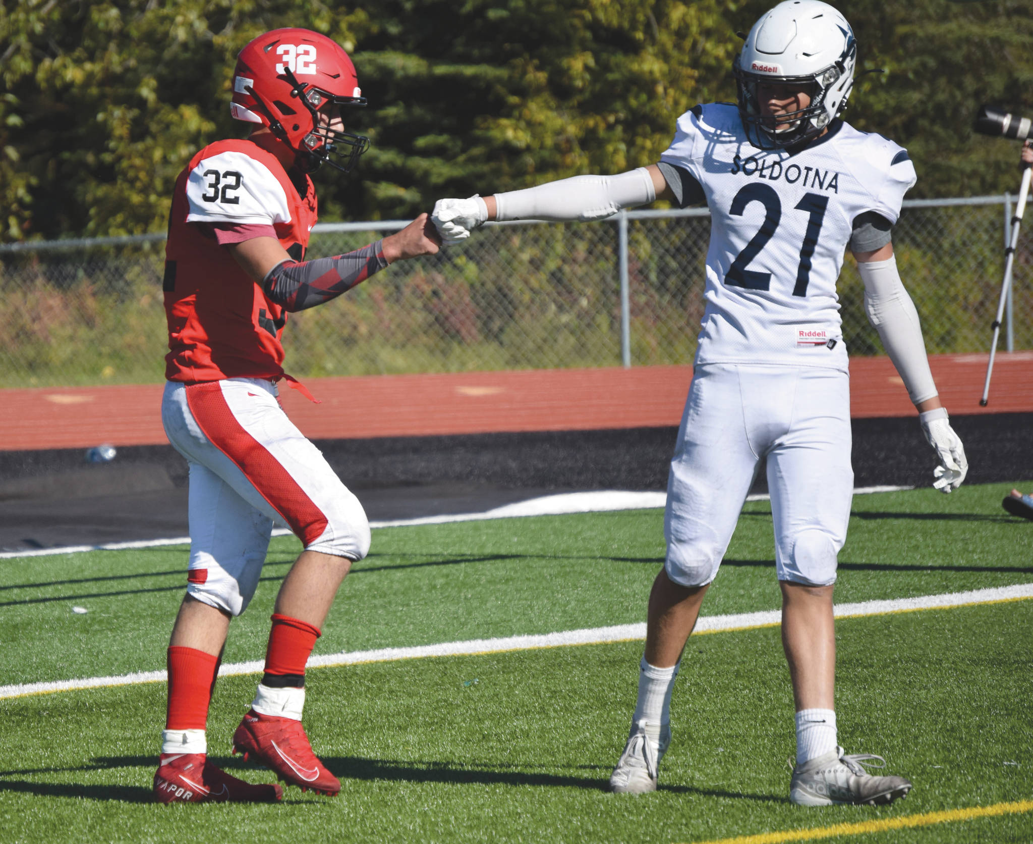 Kenai Central’s Tucker Vann is congratulated by Soldotna’s Brayden Taylor after scoring a touchdown Saturday, Sept. 12, 2020, at Ed Hollier Field at Kenai Central High School. Soldotna won 58-14, but Vann explained after the game he’s knows many Soldotna players through Pop Warner football. “We’re buddies whether we’re rivals or not,” Vann said. “They take care of me and I take care of them.” (Photo by Jeff Helminiak/Peninsula Clarion)