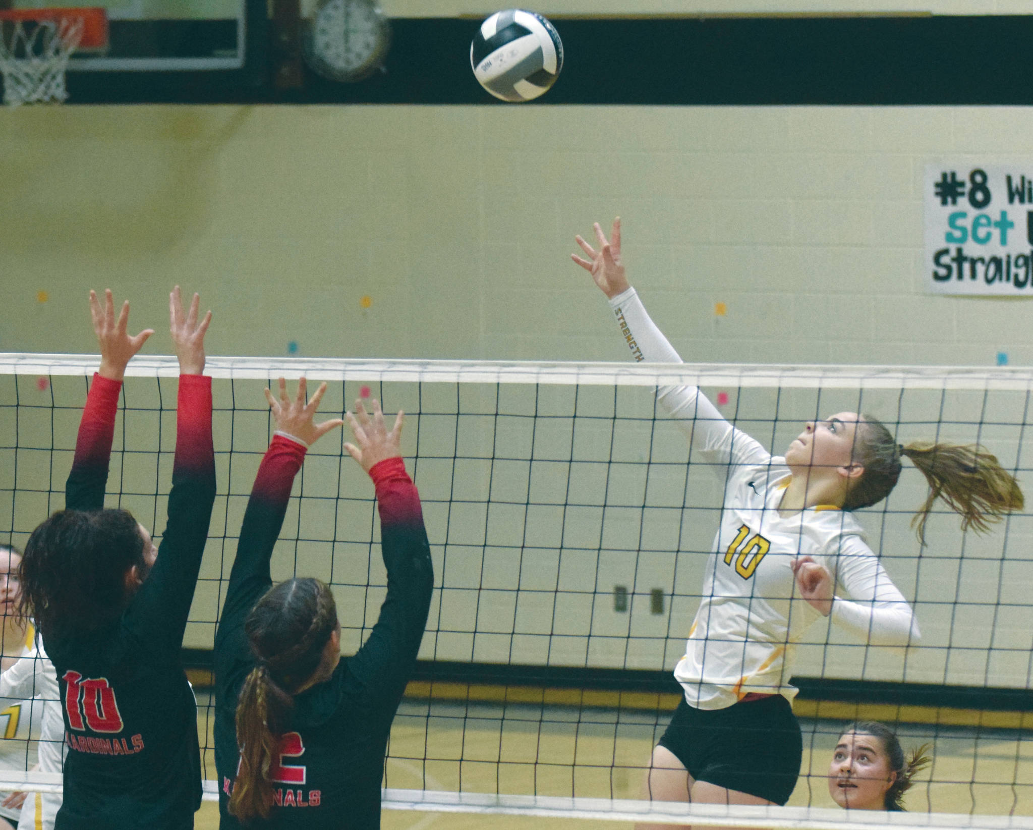 Nikiski’s Lillian Carstens attacks Kenai Central’s Abby Every and Kaylee Lauritsen on Tuesday, Sept. 29, 2020, at Nikiski High School in Nikiski, Alaska. (Photo by Jeff Helminiak/Peninsula Clarion)