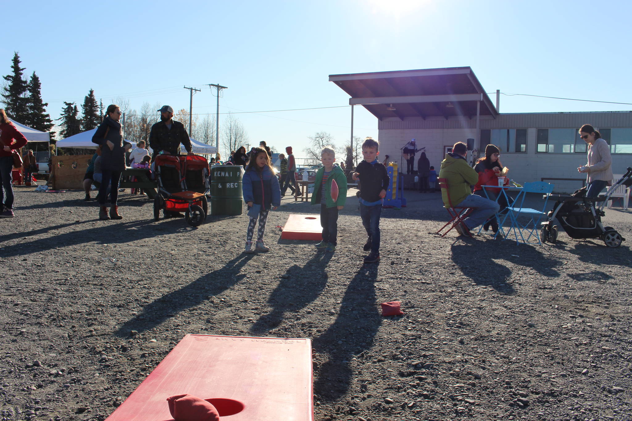 From left, Isabell Pijahn, Clark Douthit and Sawyer Douthit play a round of cornhole during the 5th annual Kenai Fall Pumpkin Festival in Kenai, Alaska on Oct. 10, 2020. (Photo by Brian Mazurek/Peninsula Clarion)