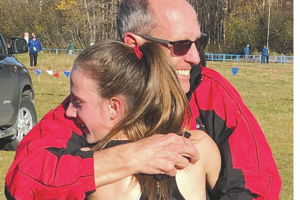 Kenai Central's Jayna Boonstra receives a hug from father and Kardinals coach, Todd Boonstra, Saturday, Oct. 10, 2020, at the ASAA cross-country running championships at Kincaid Park in Anchorage, Alaska. (Photo by Joey Klecka)