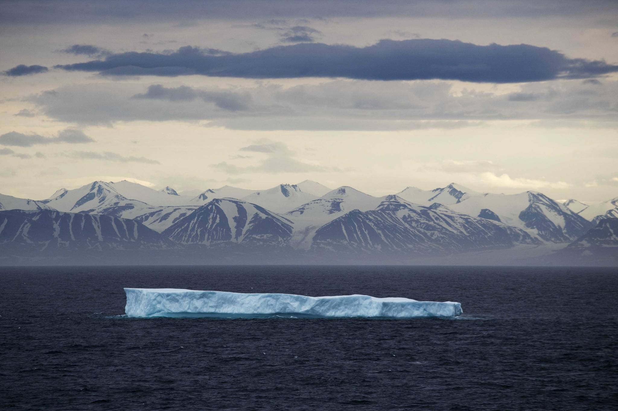 In this July 24, 2017 file photo, an iceberg floats past Bylot Island in the Canadian Arctic Archipelago. The National Oceanic and Atmospheric Administration’s annual Arctic Report Card, released on Tuesday, Dec. 8, 2020, shows how warming temperatures in the Arctic are transforming the region’s geography and ecosystems. (AP Photo/David Goldman, File)