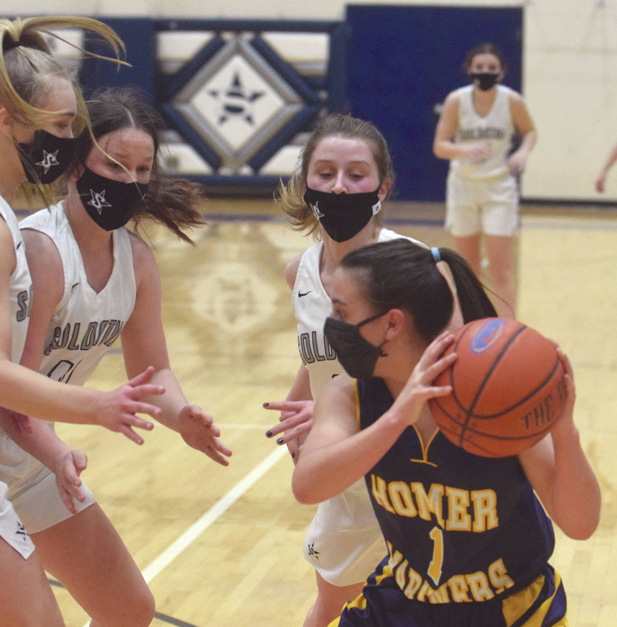 Homer's Sailey Rhodes confronts a trap of Soldotna's Jolie Widaman, Josie Sheridan and Rhys Cannava on Tuesday, Jan. 26, 2021, at Soldotna High School in Soldotna, Alaska. (Photo by Jeff Helminiak/Peninsula Clarion)