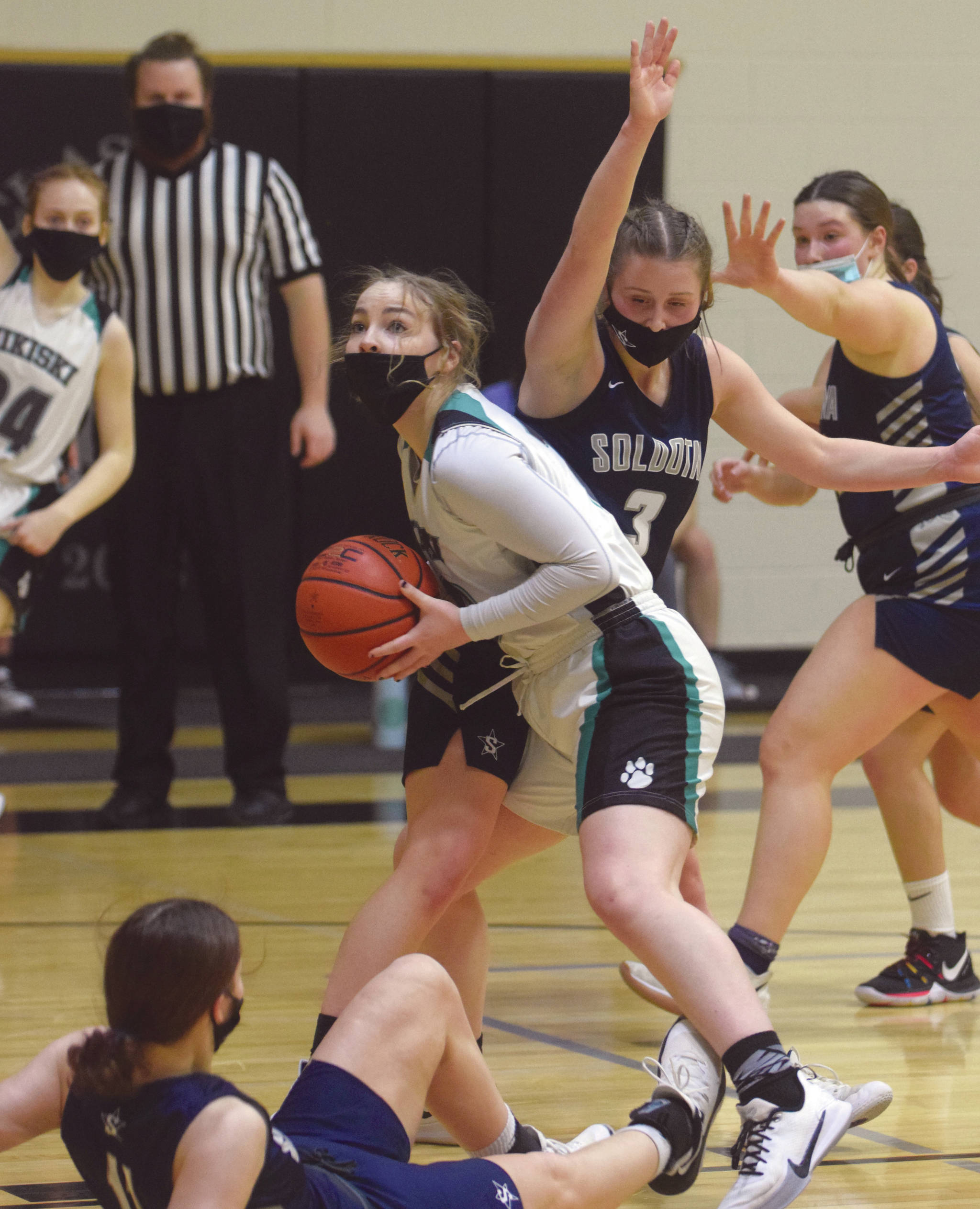 Nikiski’s Lillian Carstens drives to the basket while Soldotna’s Rhys Cannava defends Saturday at Nikiski High School in Nikiski. (Photo by Jeff Helminiak/Peninsula Clarion)