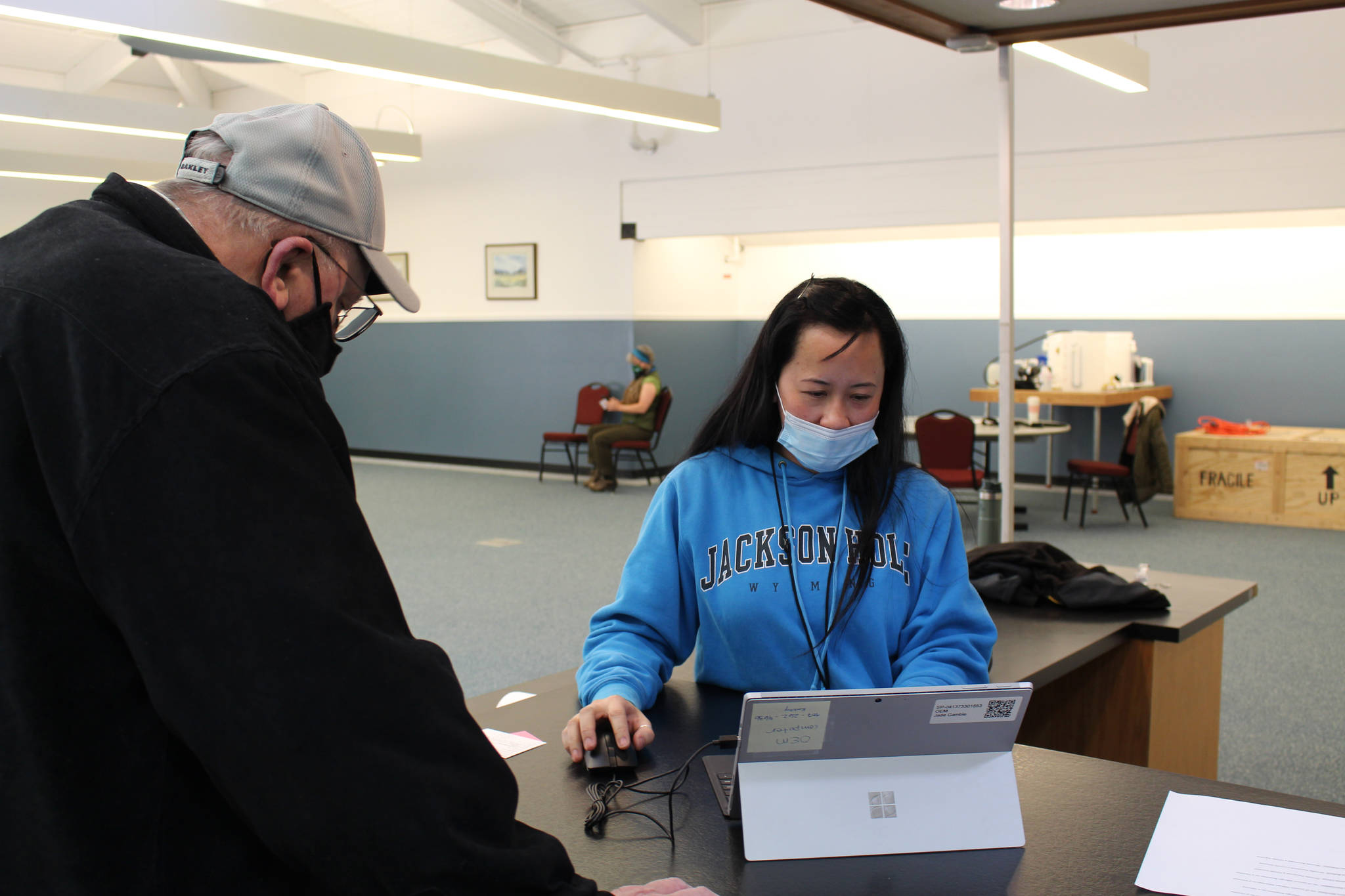 Kenai Peninsula Borough employee Kathy Trinh helps Ronald Huntsman check out after receiving his first dose of the Moderna COVID-19 vaccine during a clinic at the Nikiski Community Recreation Center on Jan. 30, 2021. (Photo by Brian Mazurek/Peninsula Clarion)
