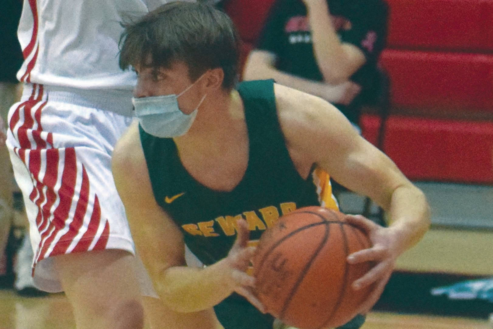 Seward's Sam Koster looks for a way around Kenai Central's Lucas Tunseth and Keagen Medina on Thursday, Feb. 18, 2021, at Kenai Central High School in Kenai, Alaska. (Photo by Jeff Helminiak/Peninsula Clarion)