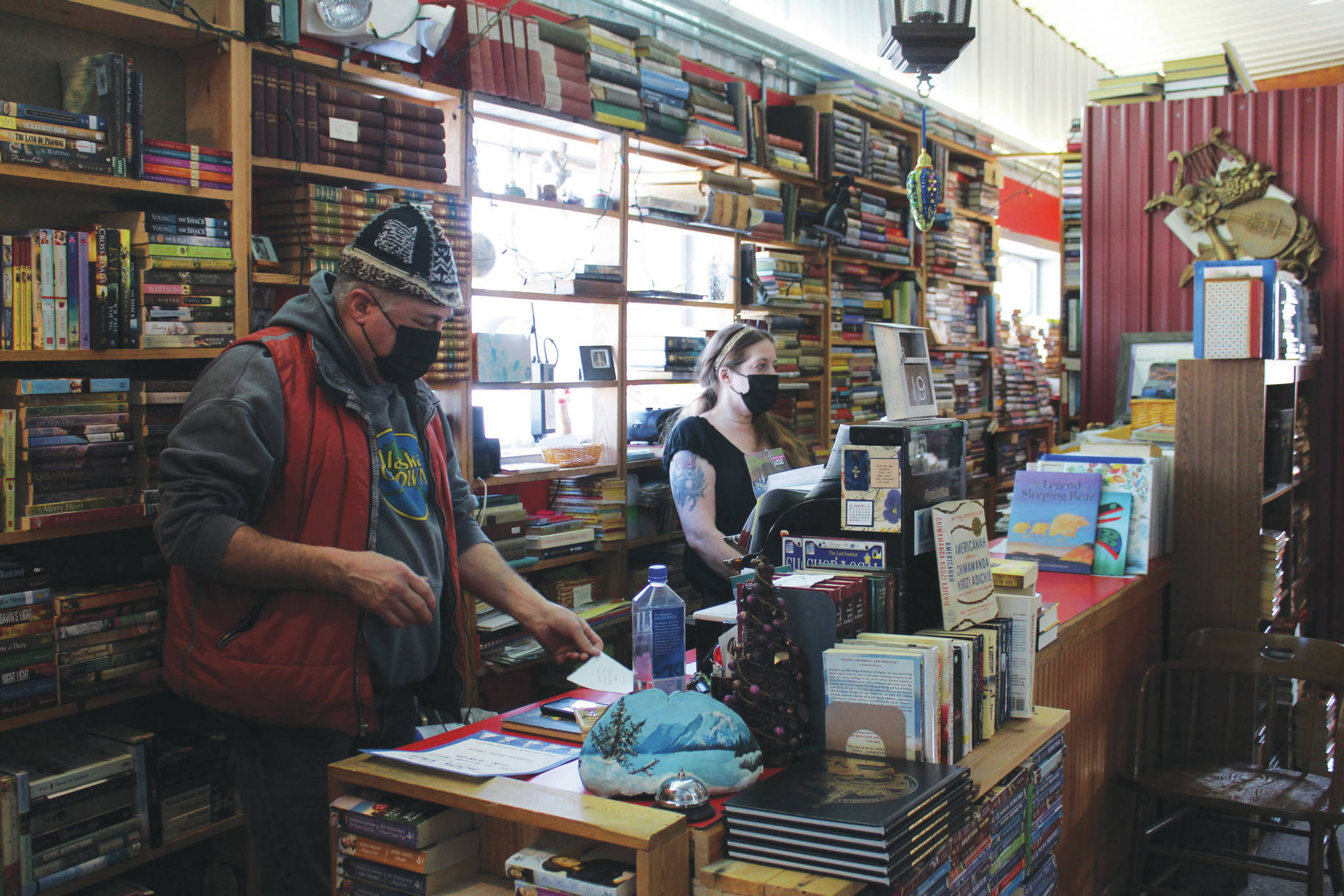 Benjamin Jackinsky (left) and Sarah O’Brien conduct business in Already Read on Friday, Feb. 19 in Kenai, Alaska.