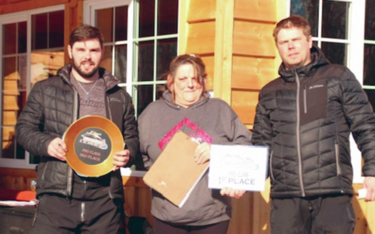 Soldotna's Travis Temple and Chad Moore accept awards from Cindi Herman of Skwentna Roadhouse after the 5th Annual Skwentna XC Snowmachine Race on Saturday, March 27, 2021. (Photo provided)