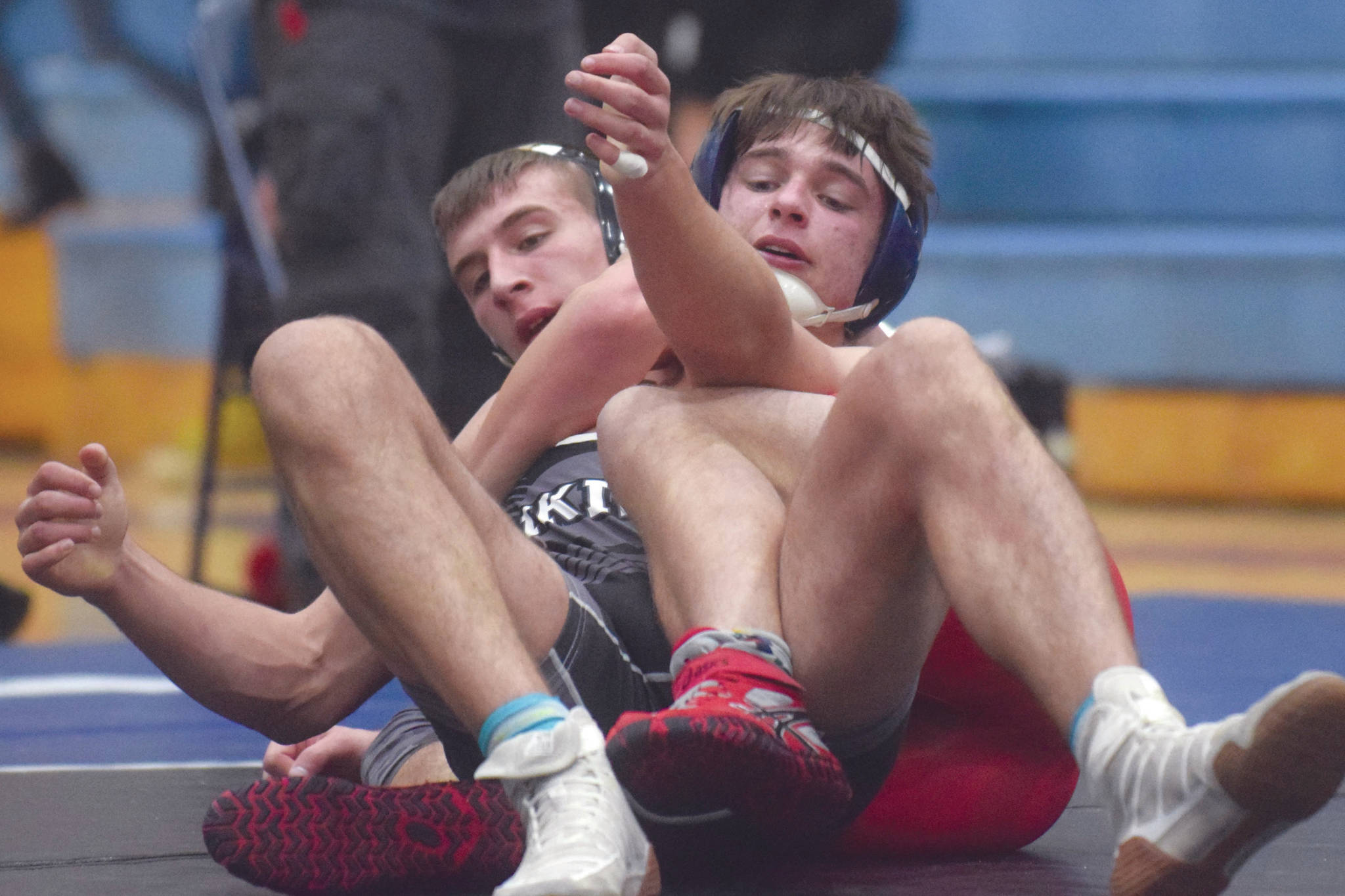 Kenai Central's Tucker Vann and Nikiski's Caileb Payne tangle Friday, April 3, 2021, at Soldotna High School in Soldotna, Alaska. Vann won by an 11-6 decision. (Photo by Jeff Helminiak/Peninsula Clarion)