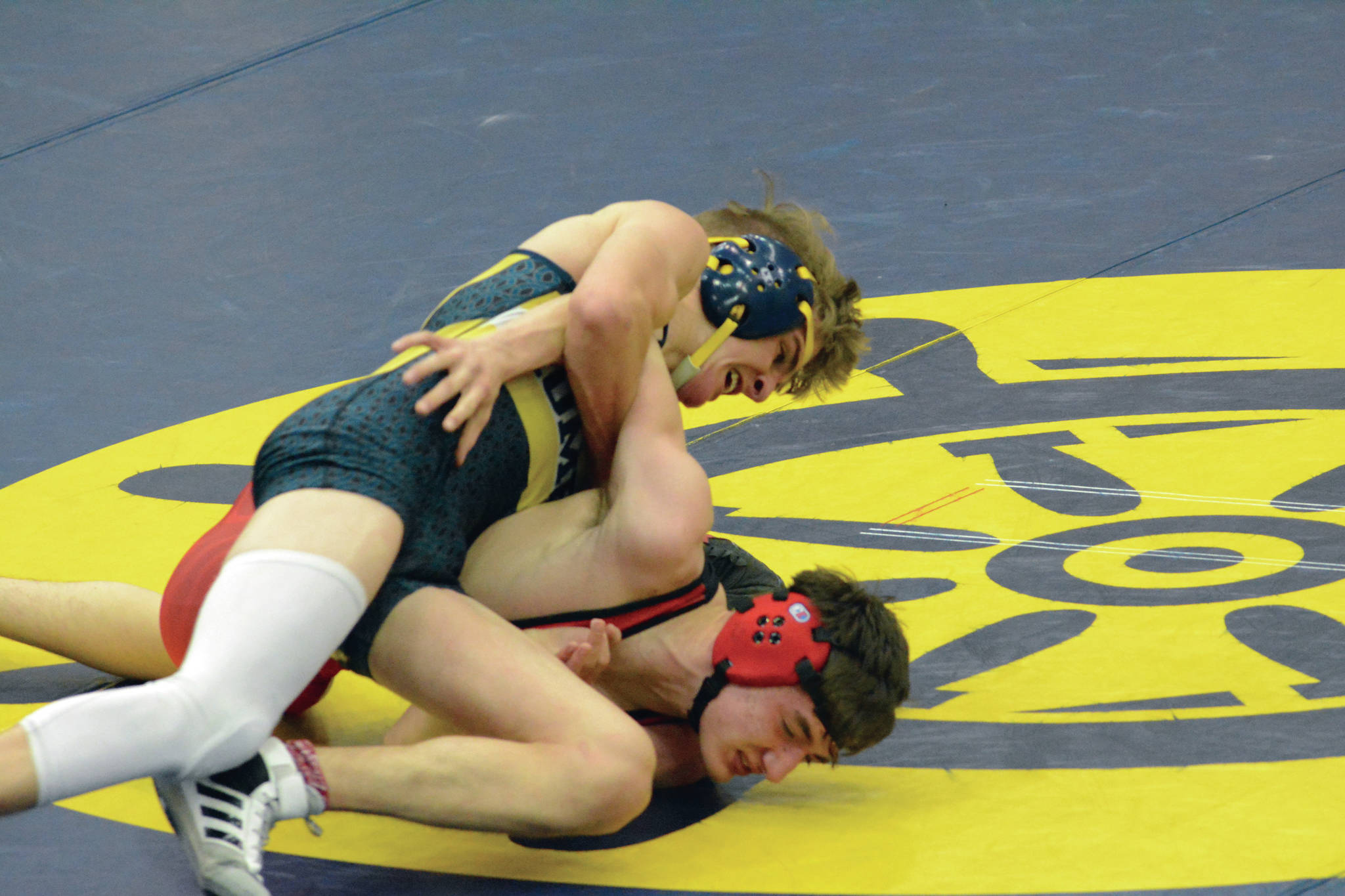 Mariner Austin Cline, top, attempts a take down of Kardinal Owen Whicker, bottom, in a wrestling meet on Tuesday, April 6, 2021, in the Alice Witte Gym at Homer High School in Homer, Alaska. (Photo by Michael Armstrong/Homer News)