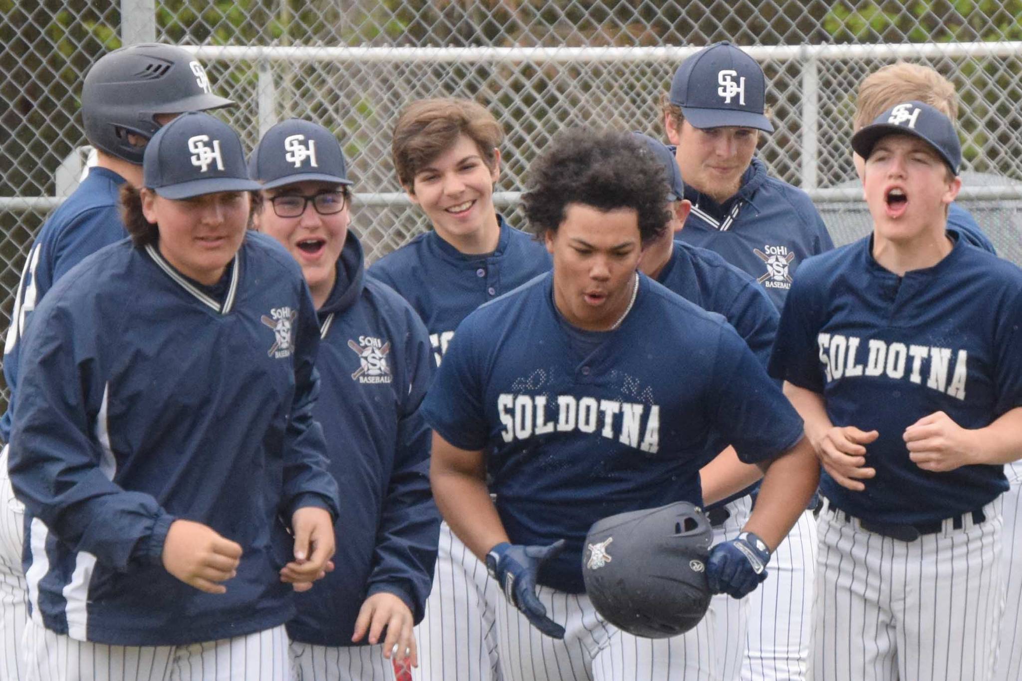 Soldotna players congratulate Atticus Gibson (center, helmet in hand) on his grand slam in the second inning against Homer on Saturday, May 29, 2021, at the Southcentral Conference tournament at the Soldotna Little League fields in Soldotna, Alaska. (Photo by Jeff Helminiak/Peninsula Clarion)