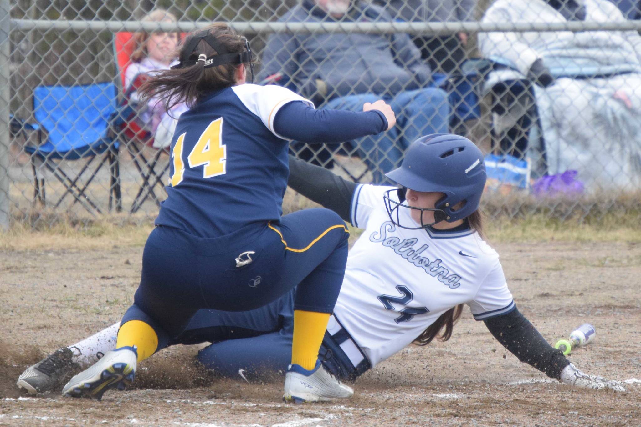 Soldotna’s Lexi Stormo slides under the tag of Homer pitcher Zoe Adkins on Thursday, May 20, 2021, in Soldotna, Alaska. (Photo by Jeff Helminiak/Peninsula Clarion)