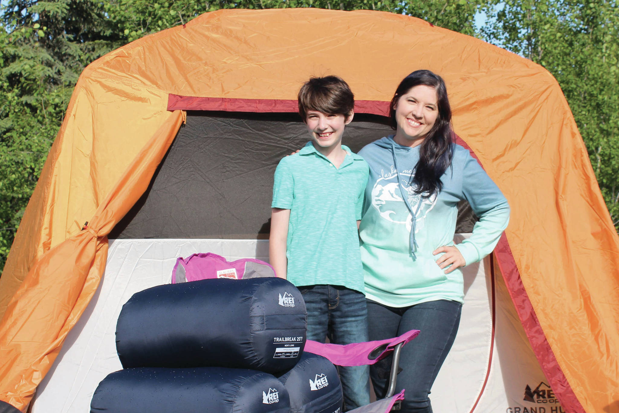 Koebryn and Summer Lazenby stand in front of camping gear at Summer's house on Tuesday, July 13, 2021 near Soldotna, Alaska. (Ashlyn O'Hara/Peninsula Clarion)