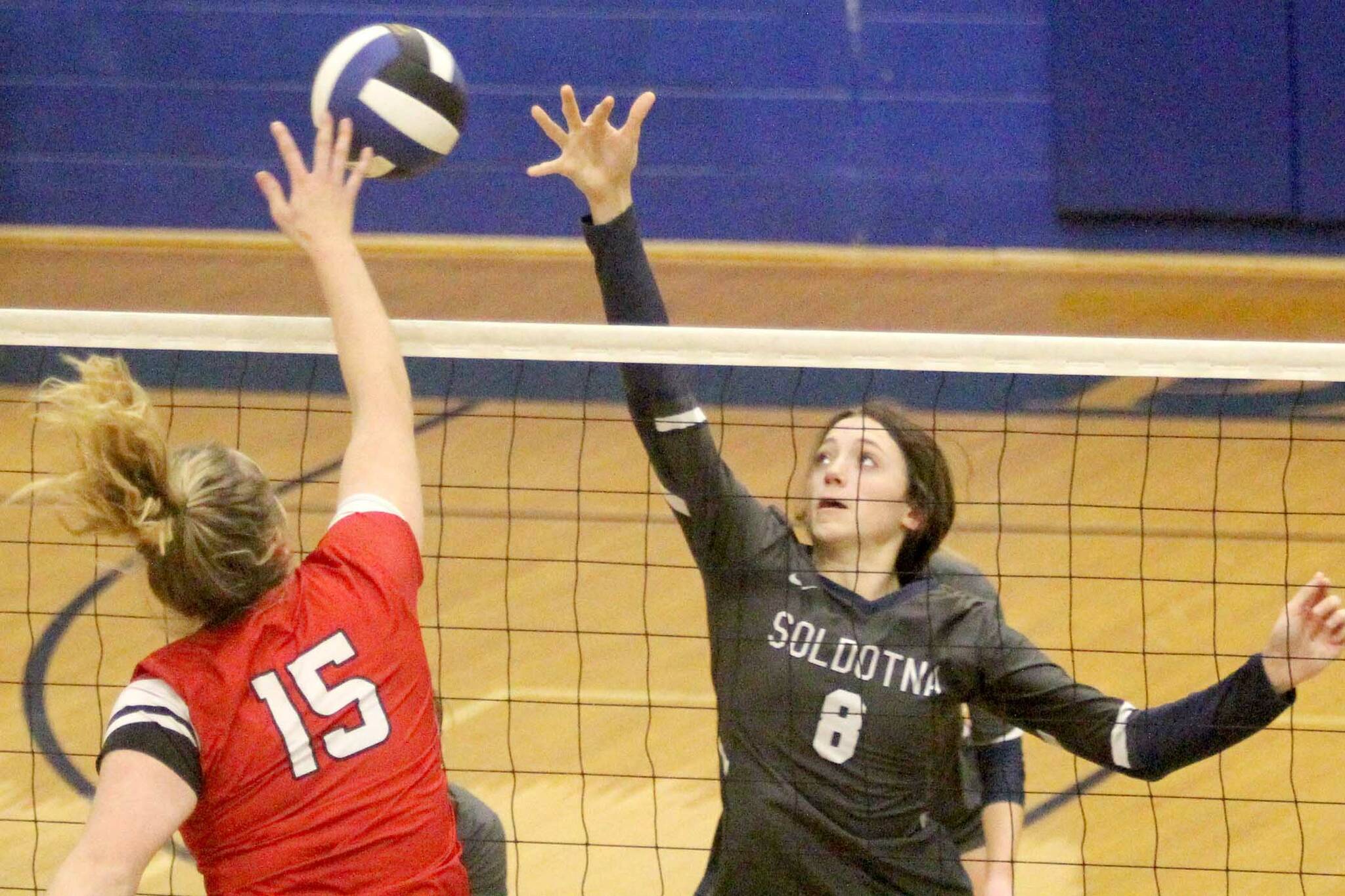 Soldotna's Adarra Hagelund reaches to try to block a hit by Wasilla's Bella Hays during a 3-0 win over the Warriors on the first day of the Northern Lights Conference tournament Friday, Nov. 4, 2021, at Palmer High School. (Jeremiah Bartz/Frontiersman)