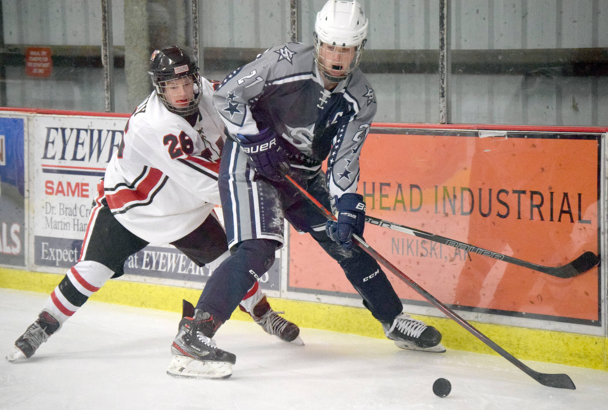 Soldotna’s Dylan Dahlgren keeps the puck from Kenai Central’s Toby Petty on Tuesday, Dec. 14, 2021, at the Kenai Multi-Purpose Facility in Kenai, Alaska. (Photo by Jeff Helminiak/Peninsula Clarion)