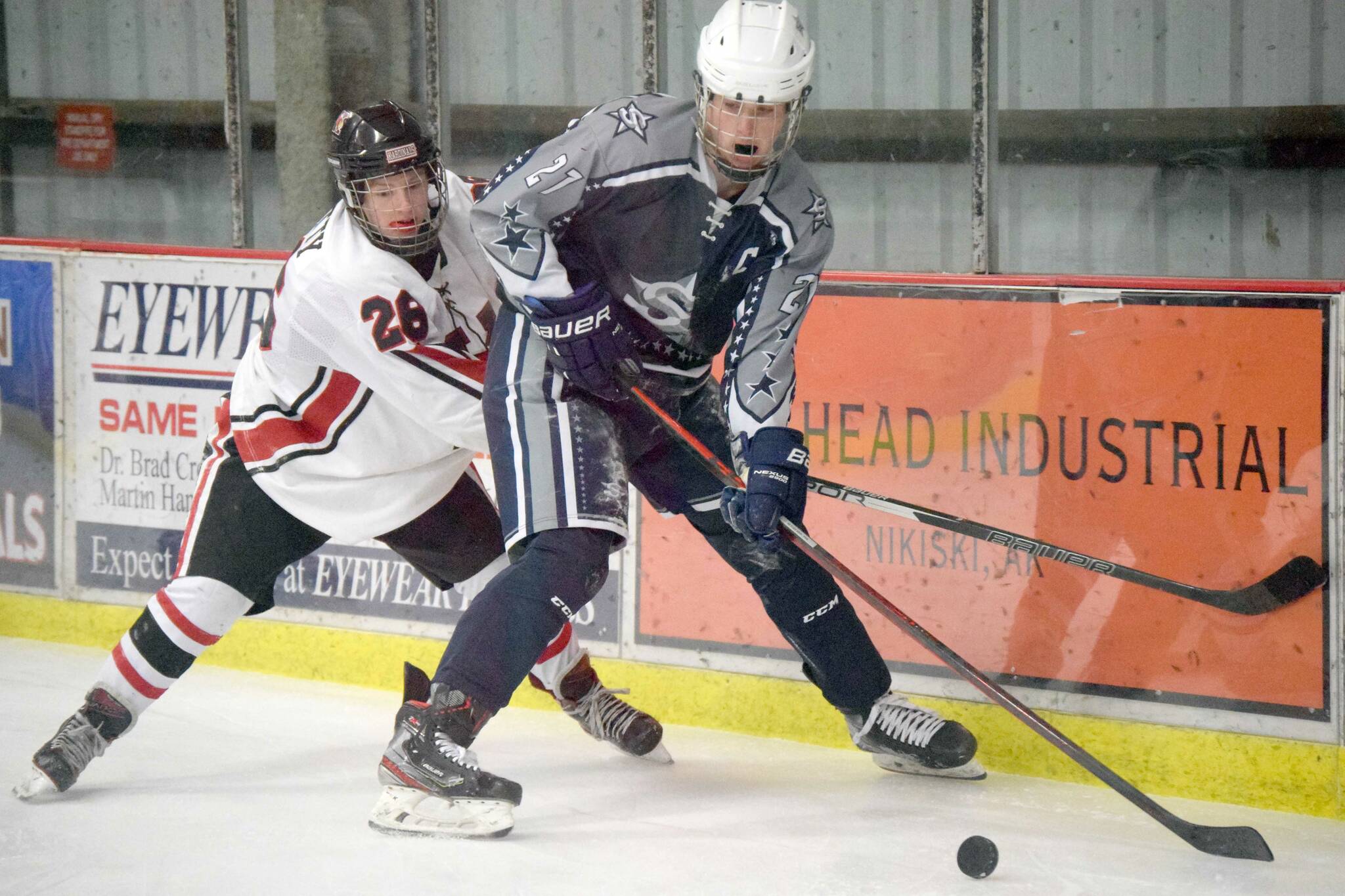 Soldotna's Dylan Dahlgren keeps the puck from Kenai Central's Toby Petty on Tuesday, Dec. 14, 2021, at the Kenai Multi-Purpose Facility in Kenai, Alaska. (Photo by Jeff Helminiak/Peninsula Clarion)